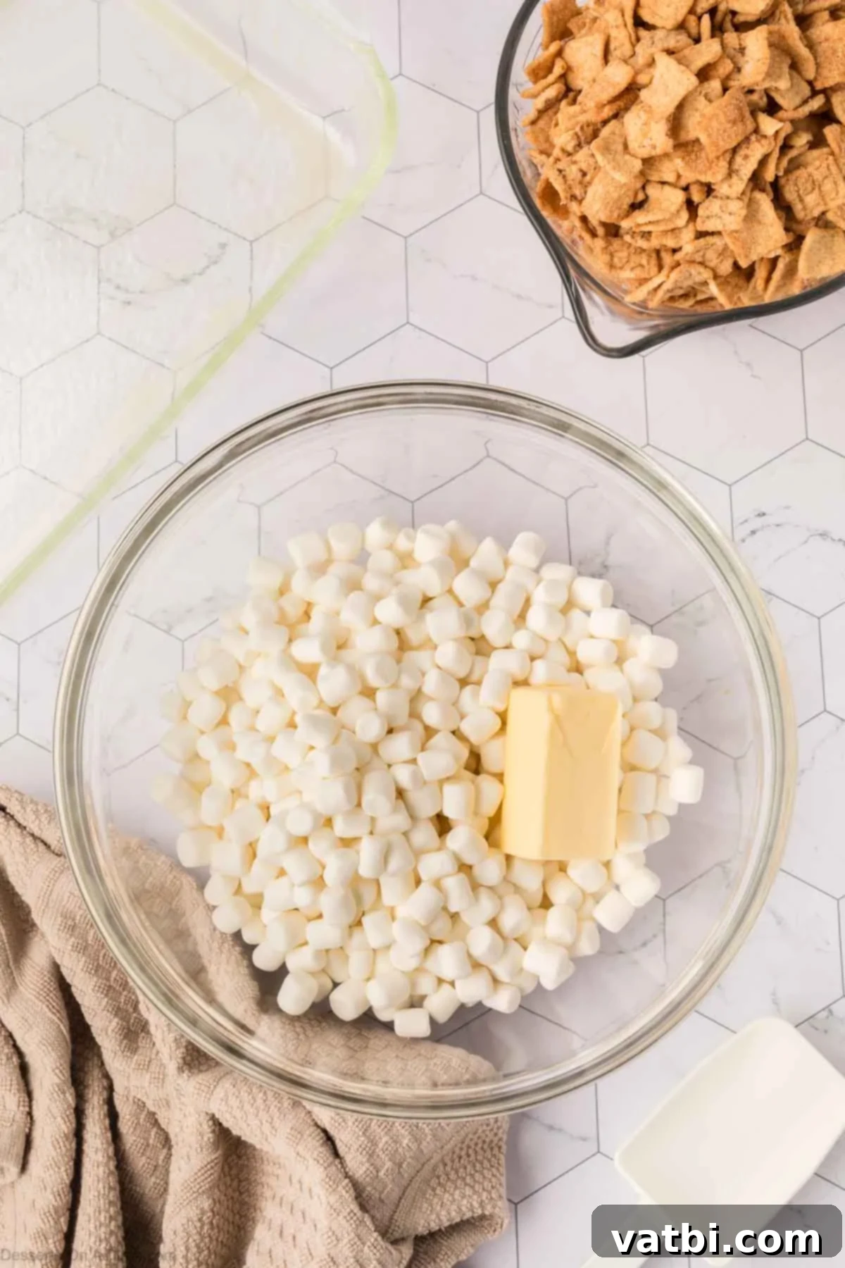 Irresistible Cinnamon Toast Crunch Bars 5 Microwave-safe mixing bowl with butter cubes and mini marshmallows, ready for melting.