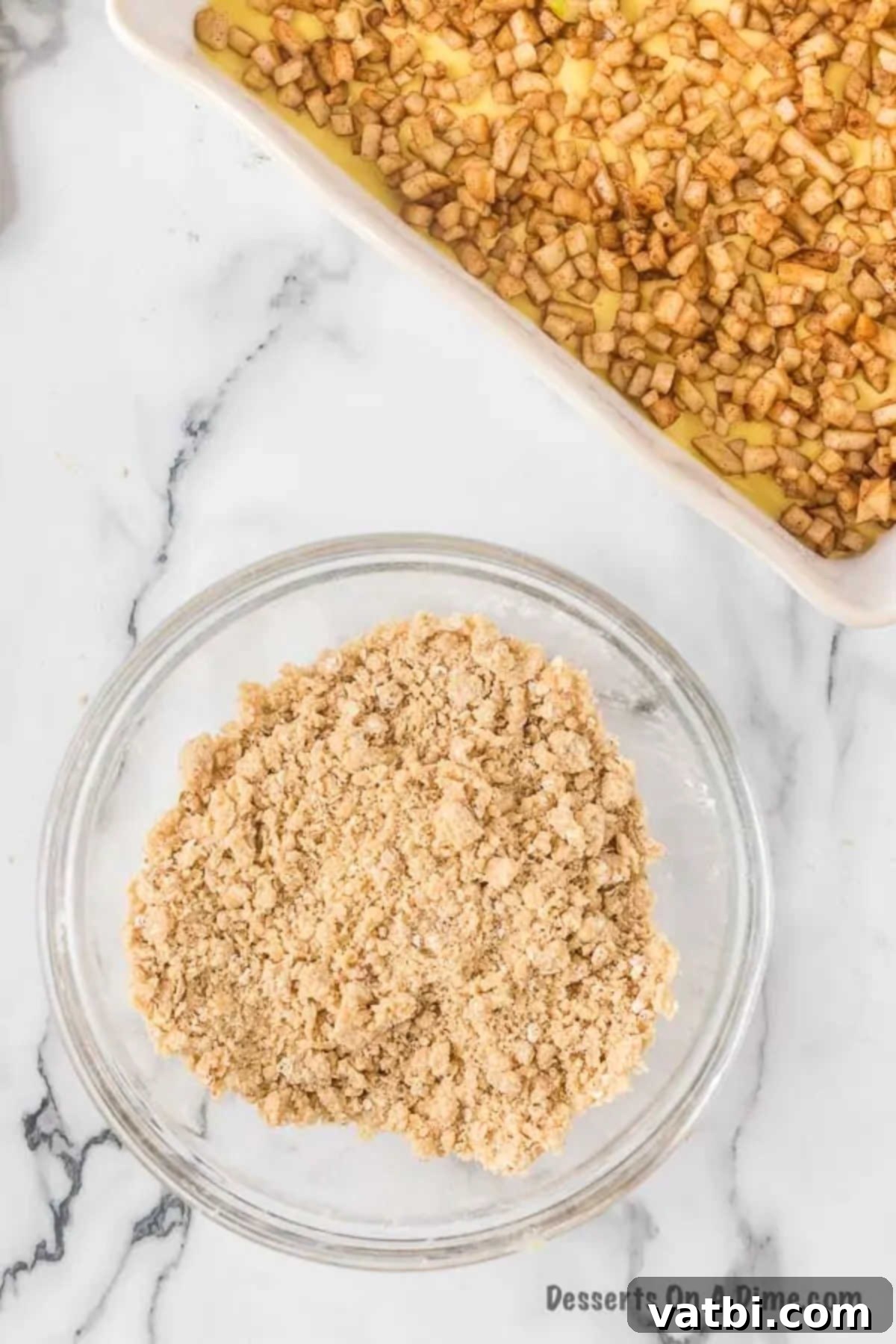 Harvest Caramel Apple Cheesecake Bars 12 A mixing bowl containing all the streusel topping ingredients—brown sugar, flour, quick oats, and softened butter—being combined by hand until a crumbly mixture forms.
