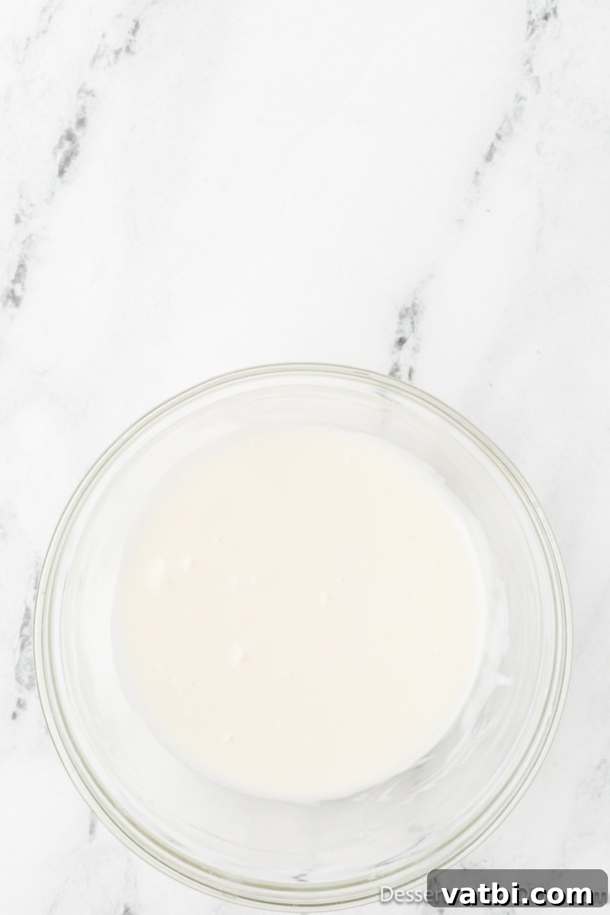 Pineapple glaze mixed to a smooth consistency in a bowl.