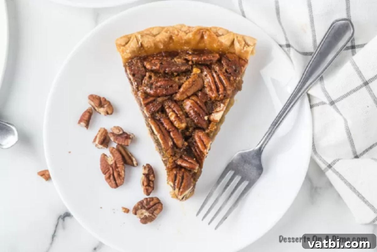 Effortless Pecan Pie Perfection 2 Slice of pecan pie on a white plate.