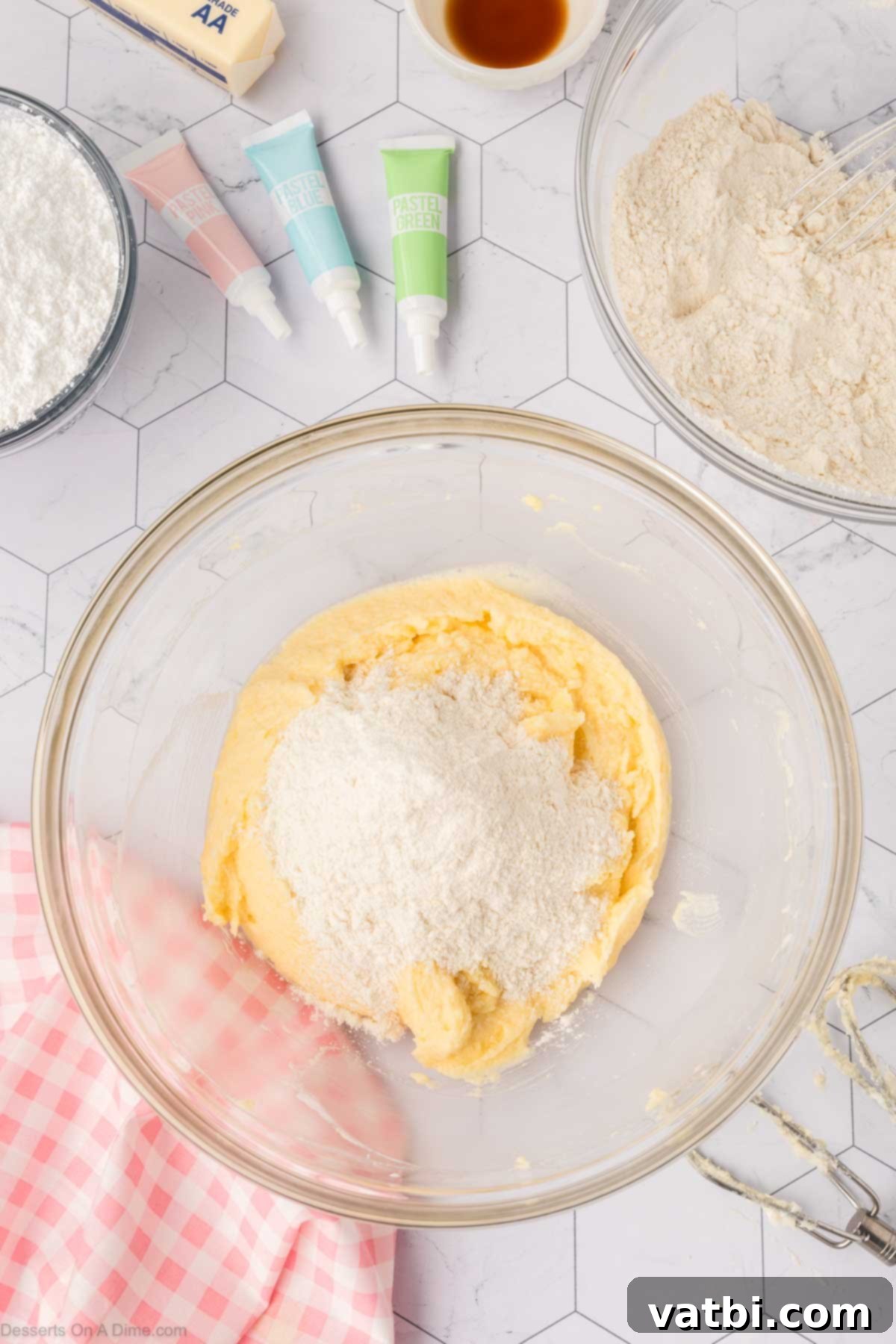 Soft Sour Cream Sugar Cookies 8 Gradually adding dry ingredients to the wet mixture for cookie dough.
