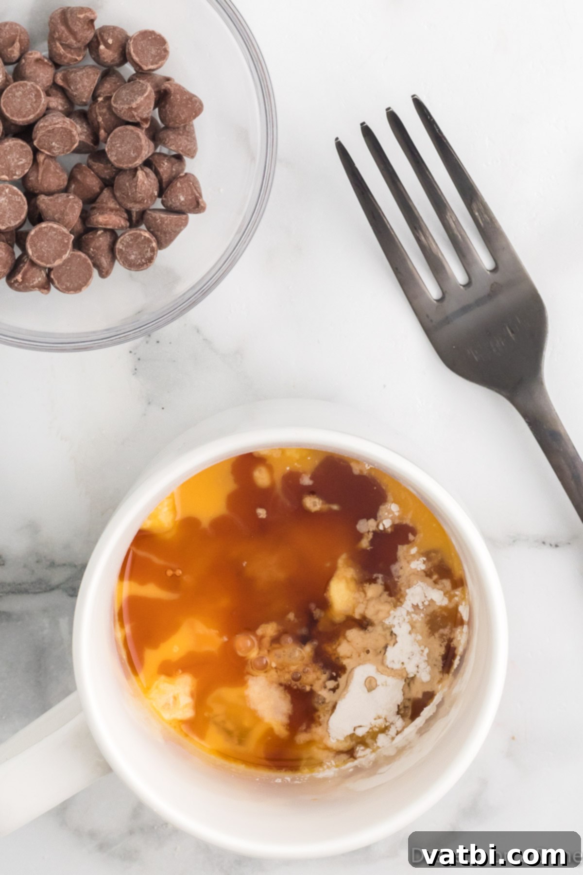 Guilt-Free Keto Chocolate Chip Mug Cake 4 Mug with all dry and wet ingredients for keto mug cake, except chocolate chips.