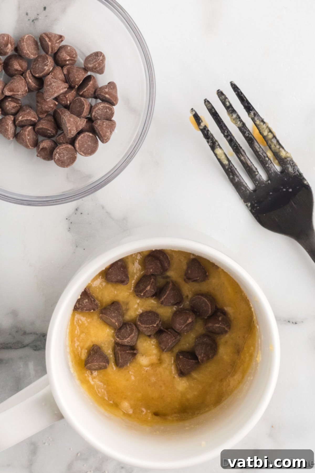 Guilt-Free Keto Chocolate Chip Mug Cake 6 Half of the chocolate chips added to the top of the keto mug cake batter.