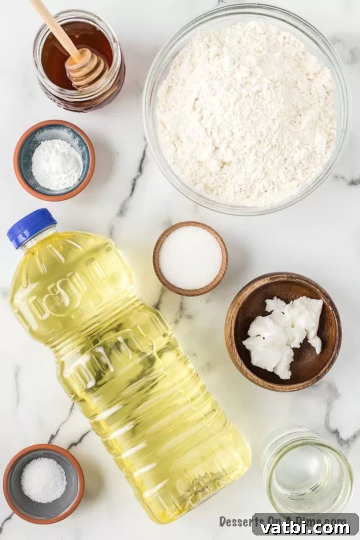 Golden & Fluffy Sopapillas: The Perfect Sweet Treat 3 Ingredients laid out for sopapilla recipe: oil, flour, sugar, baking powder, salt, vegetable shortening, honey.