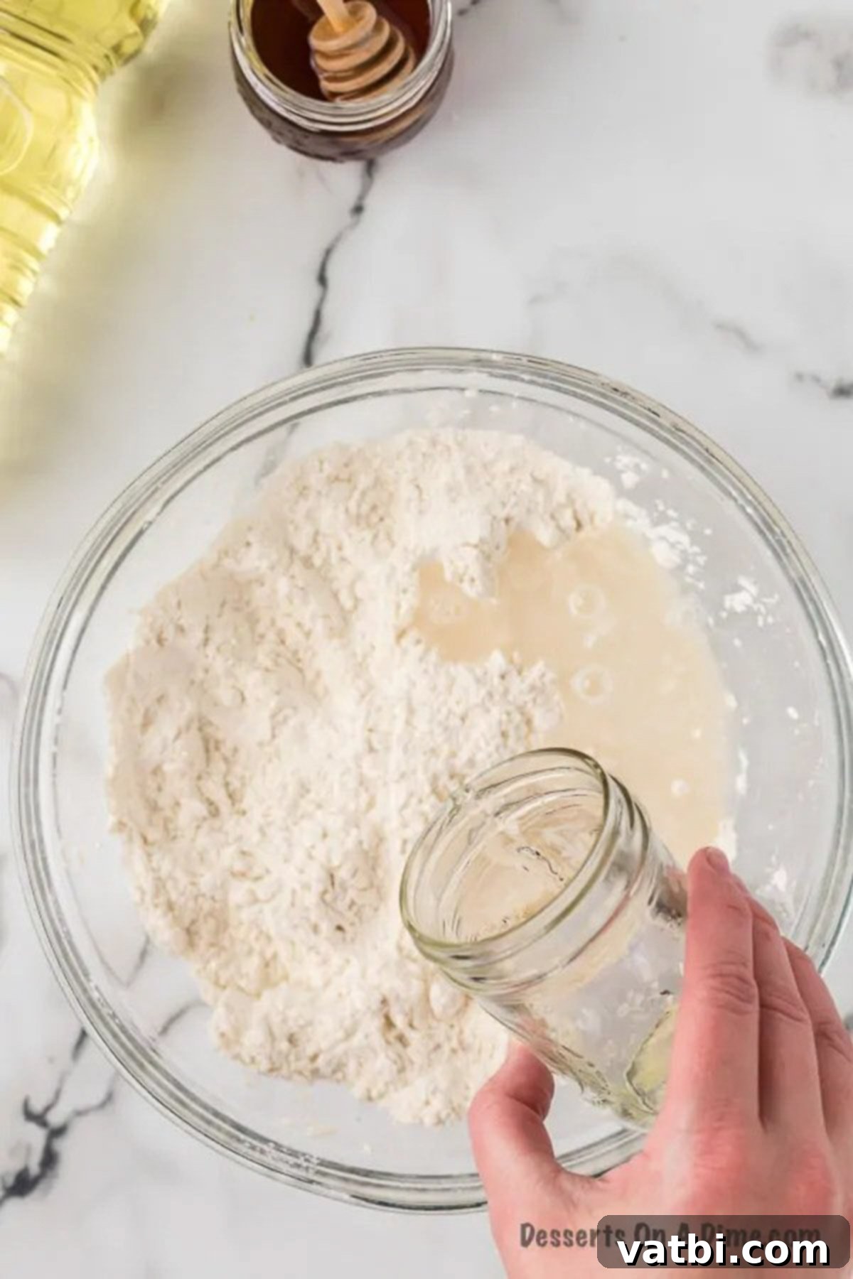 Golden & Fluffy Sopapillas: The Perfect Sweet Treat 6 Warm water being poured into the mixing bowl with dough ingredients.