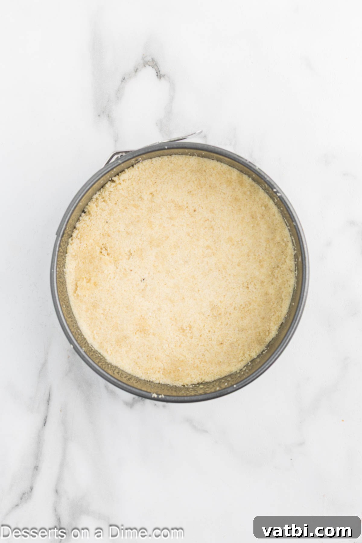 Rustic Farmhouse Cheesecake 4 Almond flour crust mixture evenly pressed into the bottom of a springform pan, ready for baking to golden perfection.