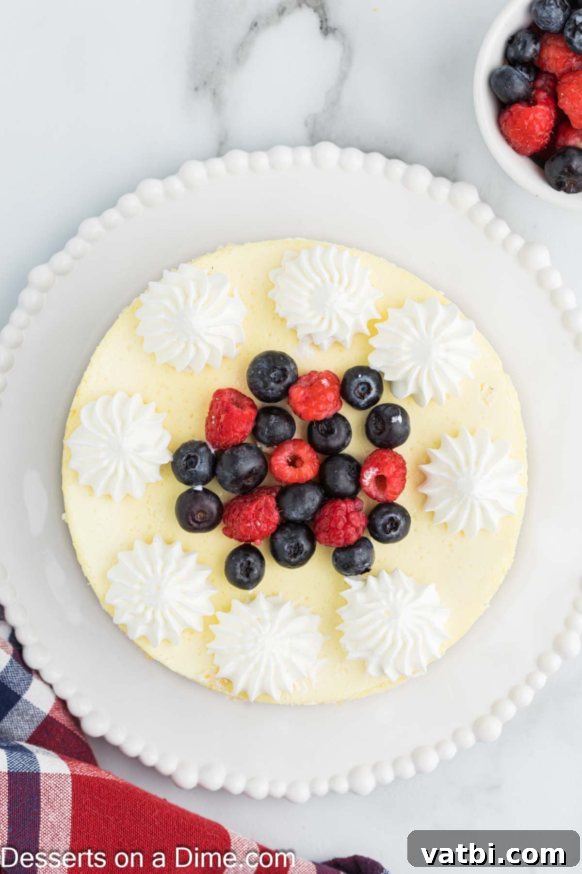 Rustic Farmhouse Cheesecake 10 A whole cottage cheese cheesecake beautifully decorated with fresh mixed berries and whipped cream, ready to be sliced and served.