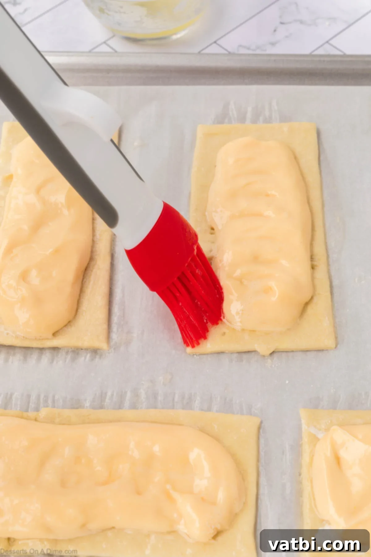 Heavenly Cream Cheese Danish 11 Pastry brush brushing egg whites on sides.