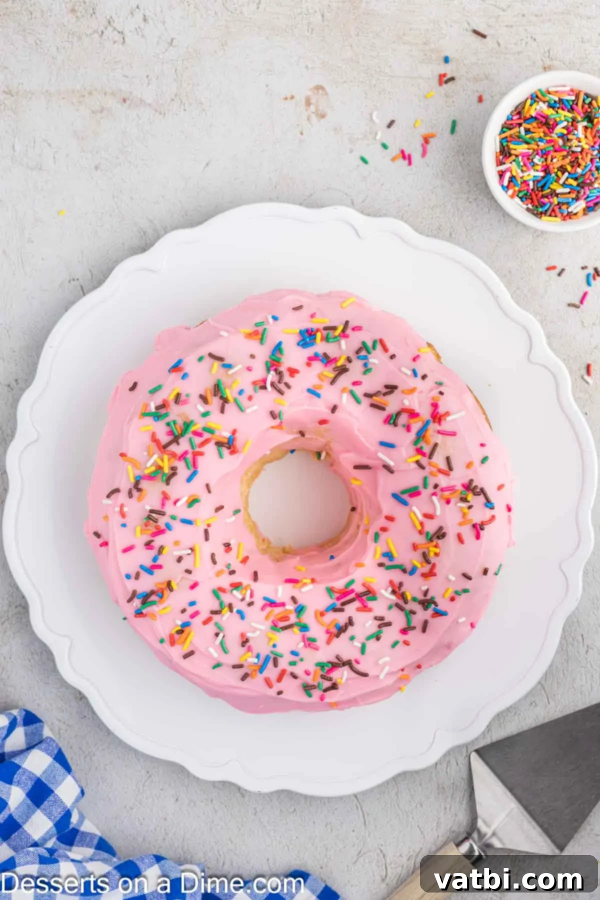 Donut Cake Delight 9 A beautifully glazed donut cake, generously topped with colorful sprinkles, presented on a serving platter, ready to be enjoyed.