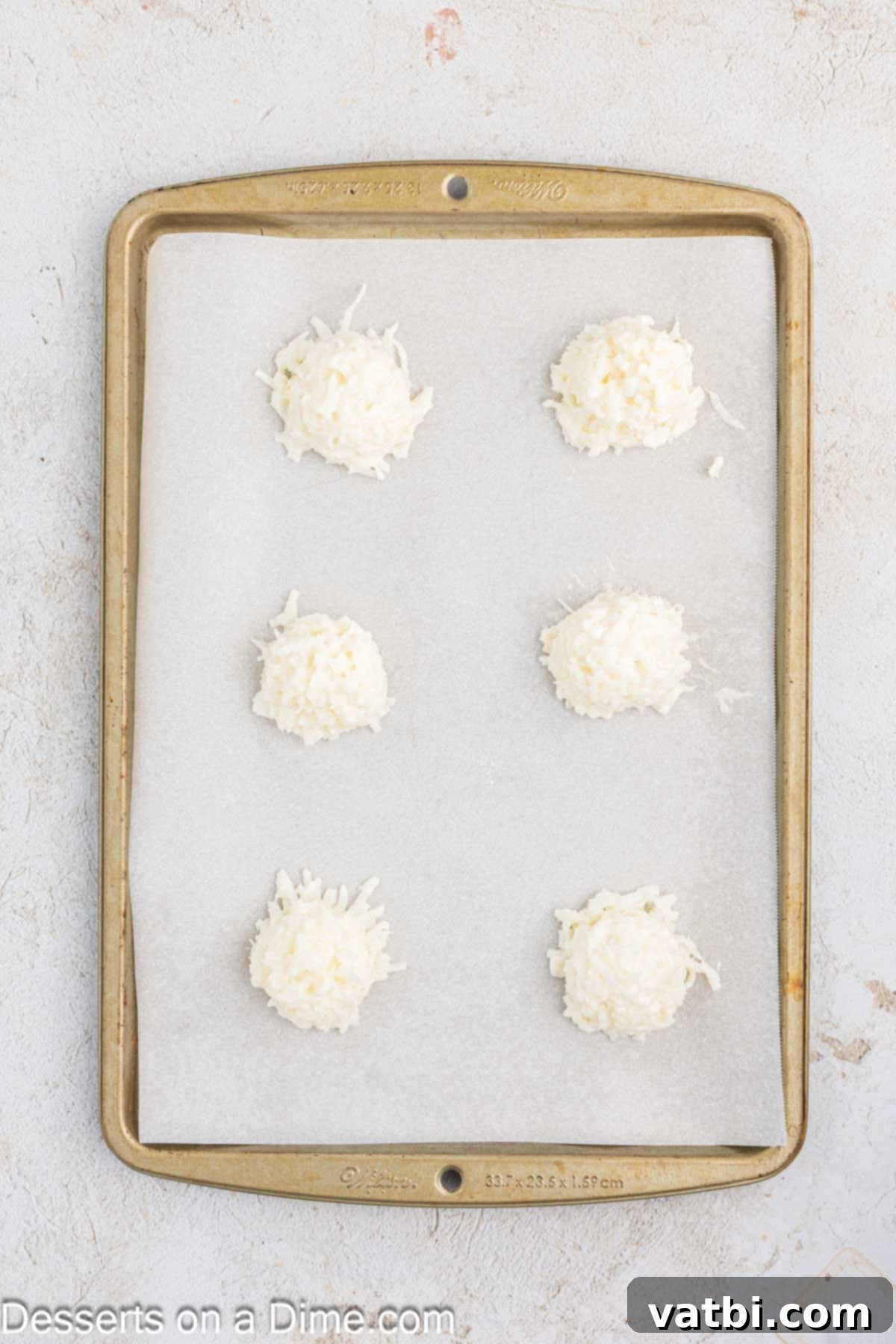 Chewy Coconut Macaroons 7 Coconut Macaroons on a baking sheet.