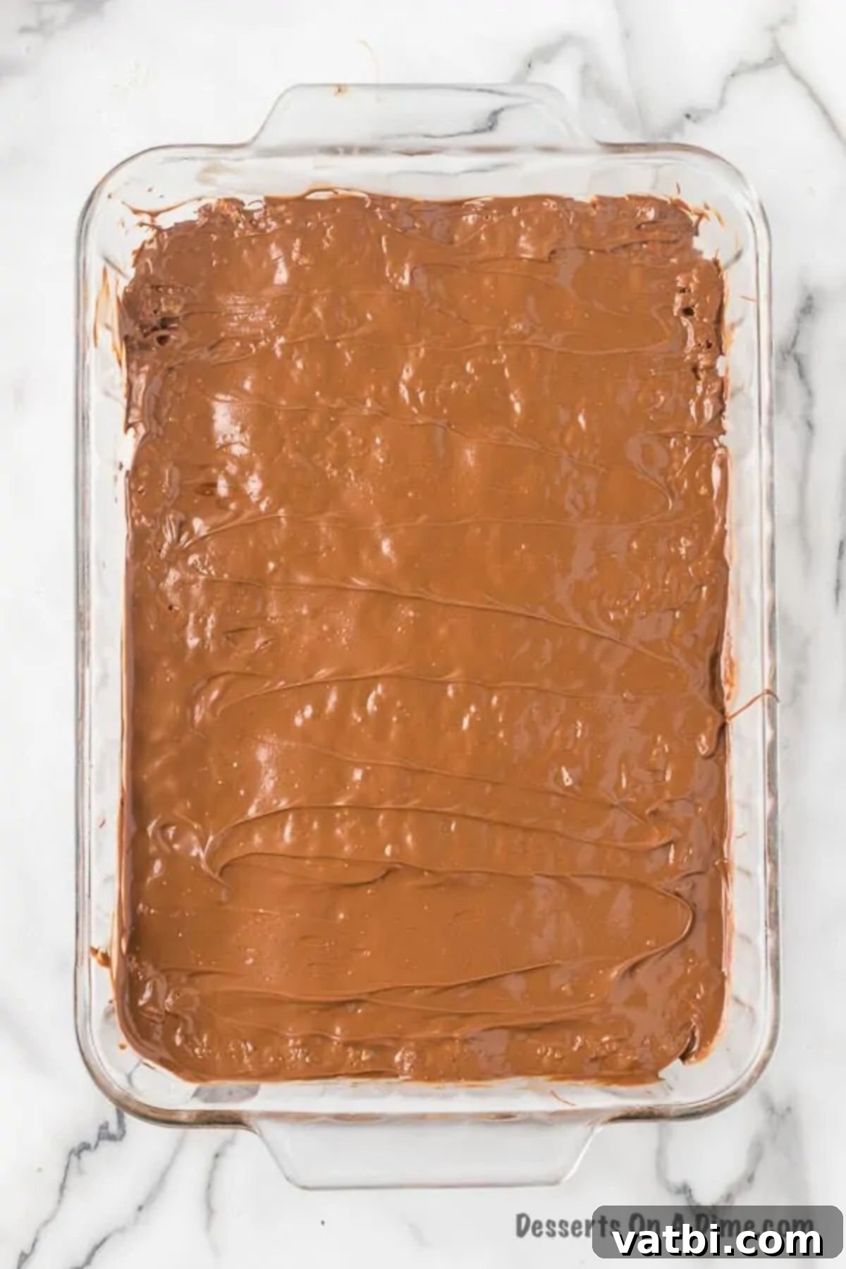 The pan of Scotcheroos base covered with the shiny, melted chocolate and butterscotch topping.