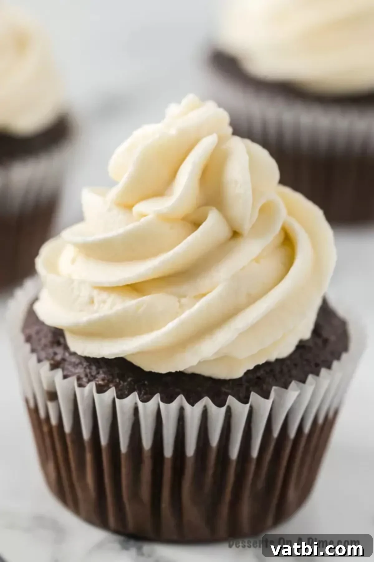 Close up of chocolate cupcake topped with homemade marshmallow frosting, showcasing its fluffy texture.