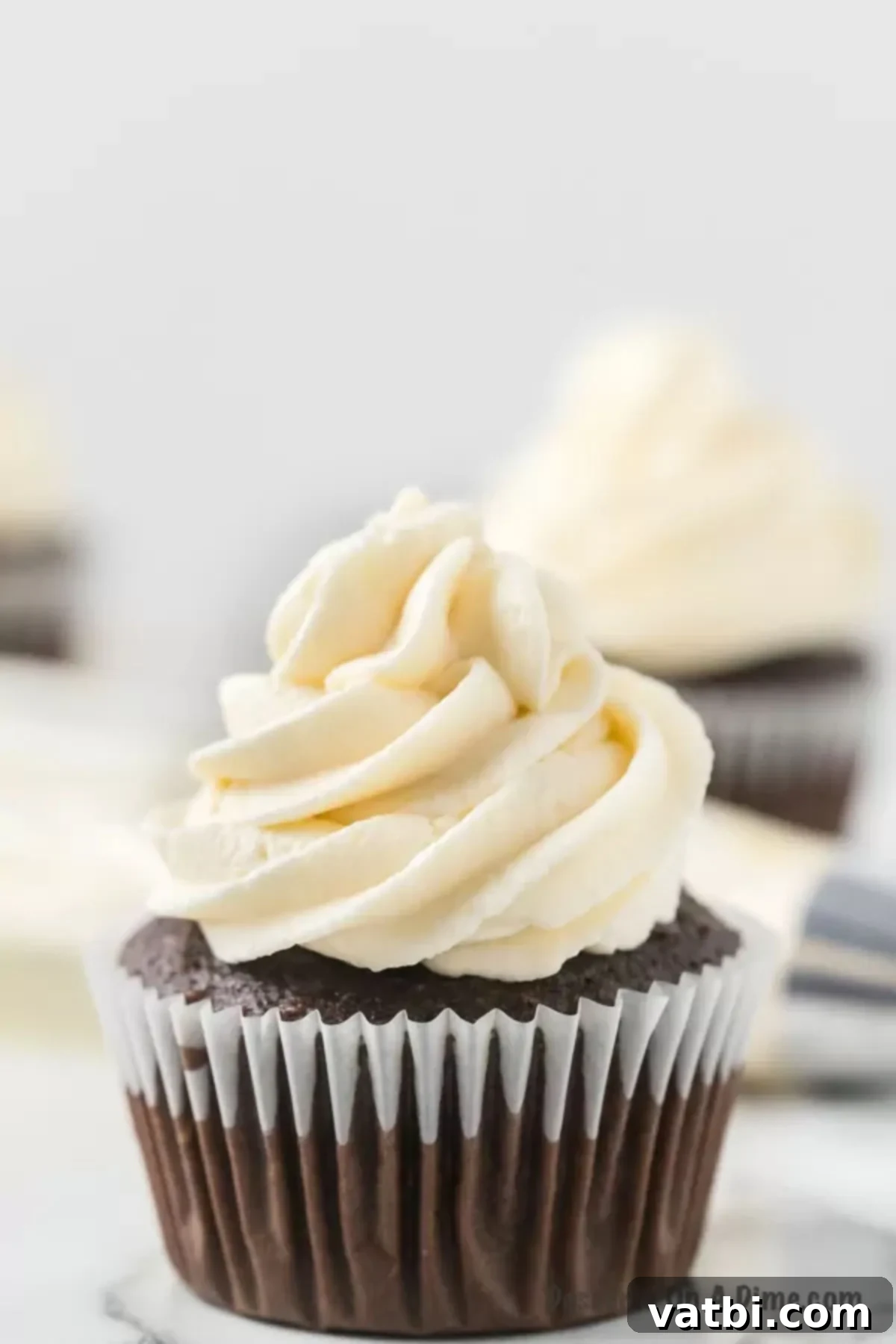 Close up of a fluffy homemade marshmallow frosting on a chocolate cupcake.