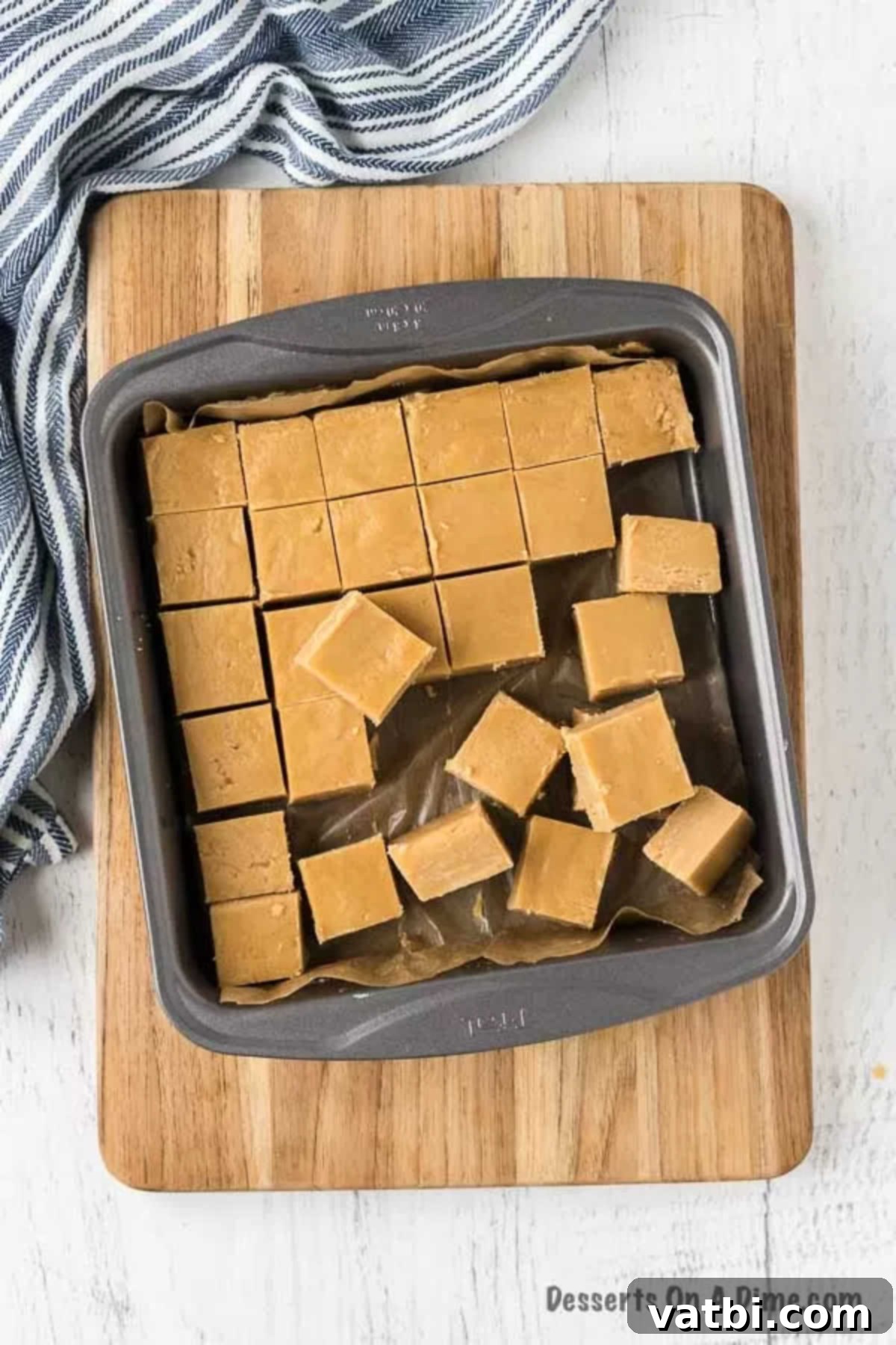 Easy 3-Ingredient Peanut Butter Fudge 11 Hand removing a perfectly cut square of peanut butter fudge from the pan.