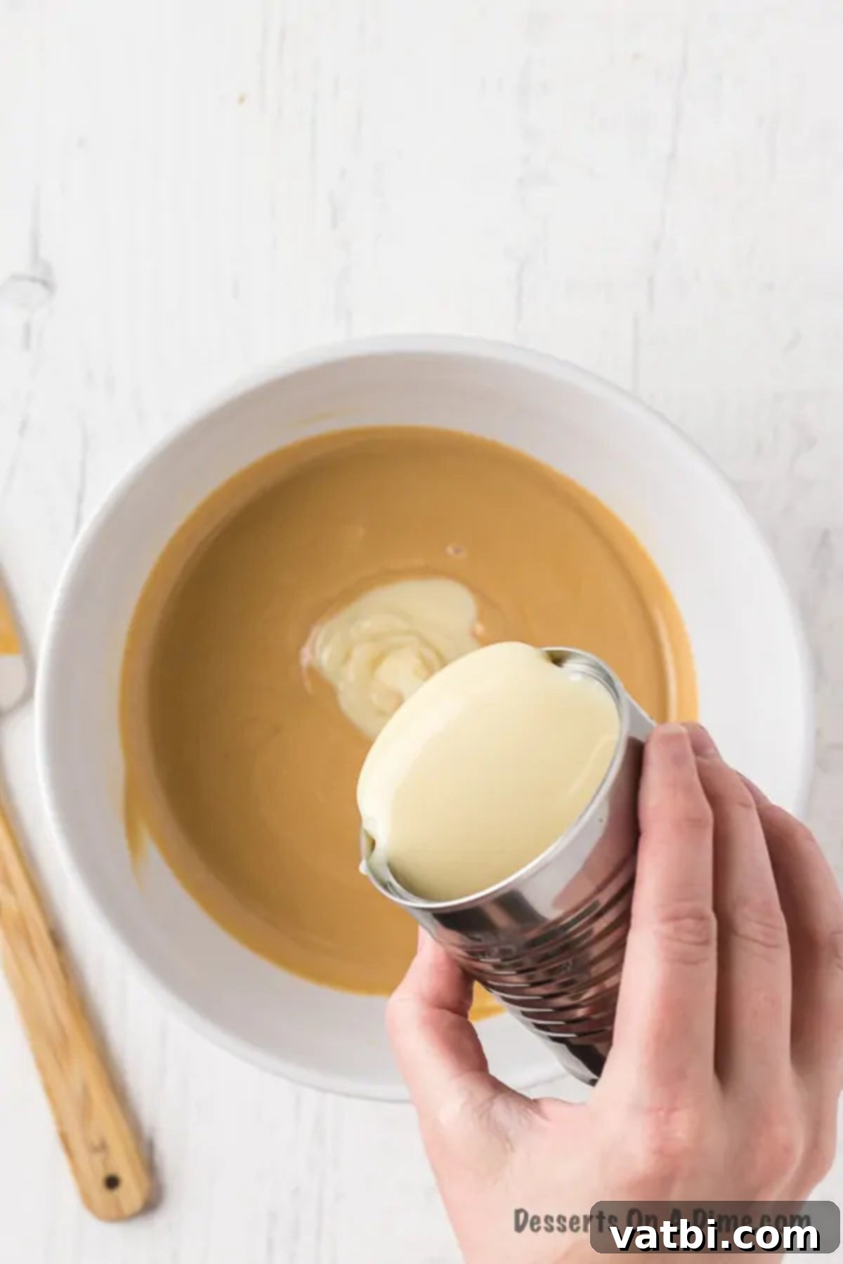 Easy 3-Ingredient Peanut Butter Fudge 6 Sweetened condensed milk being poured into the melted peanut butter and chocolate mixture.