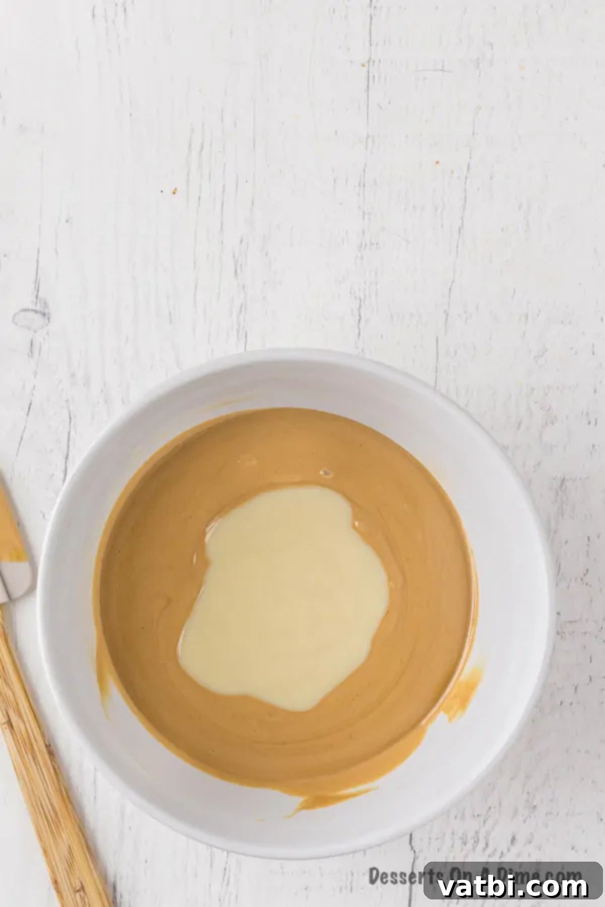 Easy 3-Ingredient Peanut Butter Fudge 7 The fudge mixture being thoroughly combined in a bowl with a spatula.