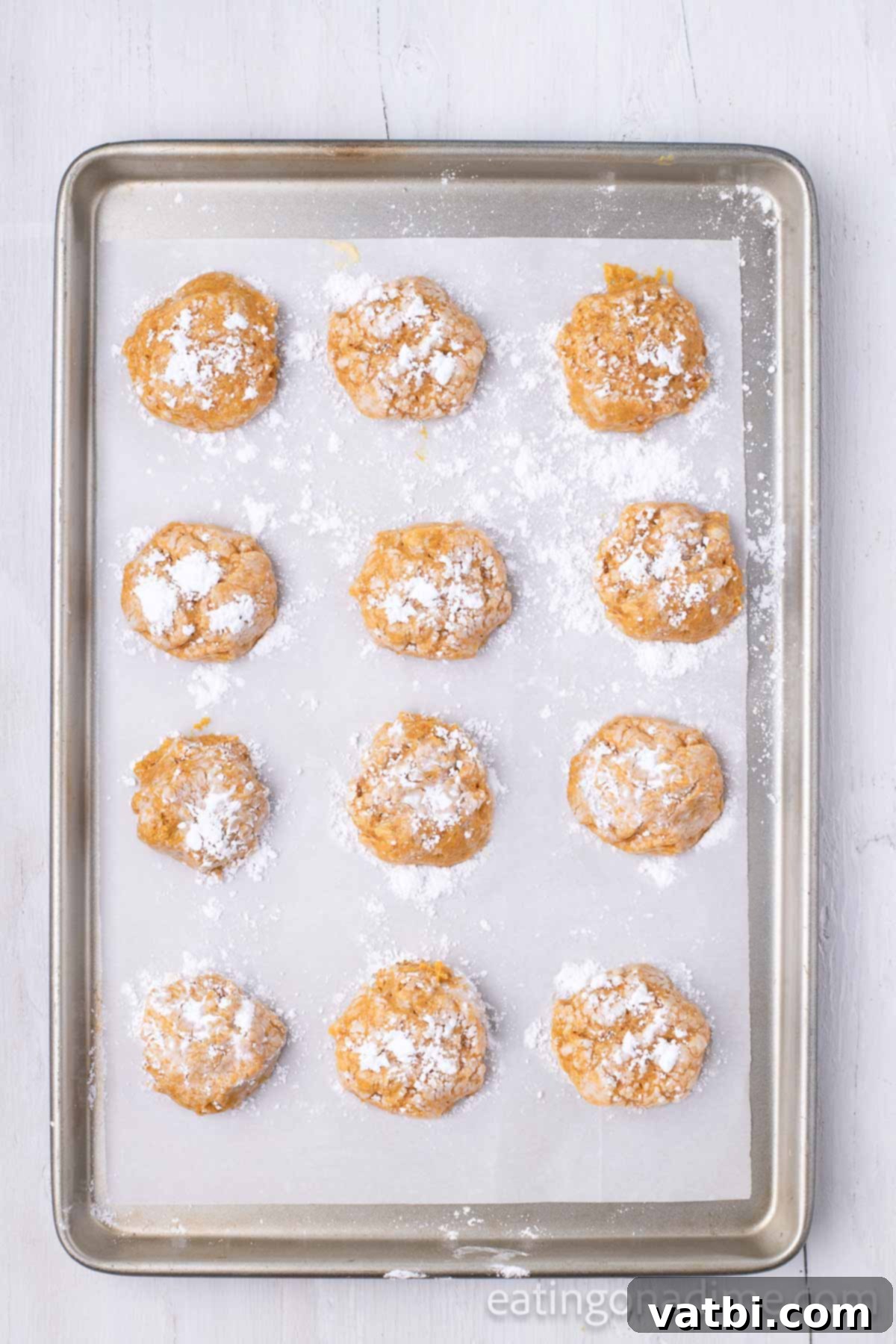 Cookies dipped in powdered sugar and placed on baking sheet. 