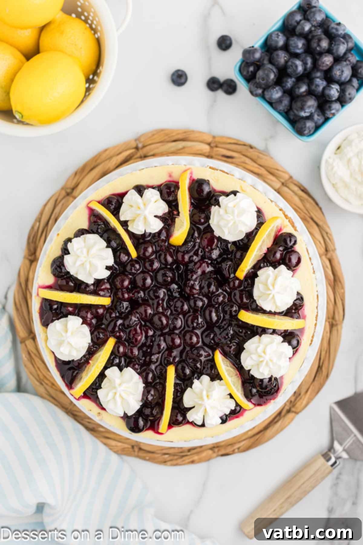 Luscious Lemon Blueberry Cheesecake 11 Finished Lemon Blueberry Cheesecake garnished with fresh blueberries, whipped cream, and lemon slices.