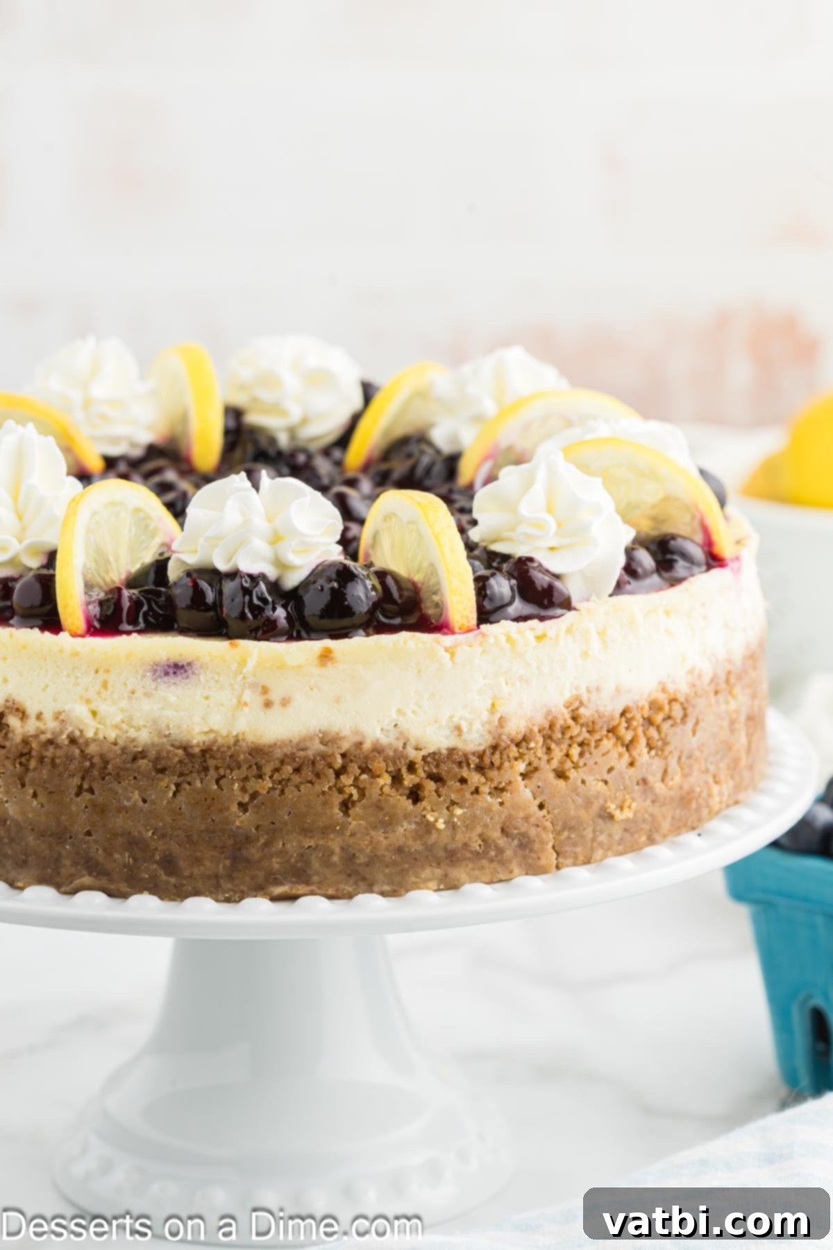 Luscious Lemon Blueberry Cheesecake 12 A slice of Lemon Blueberry Cheesecake with a vibrant blueberry topping and whipped cream.