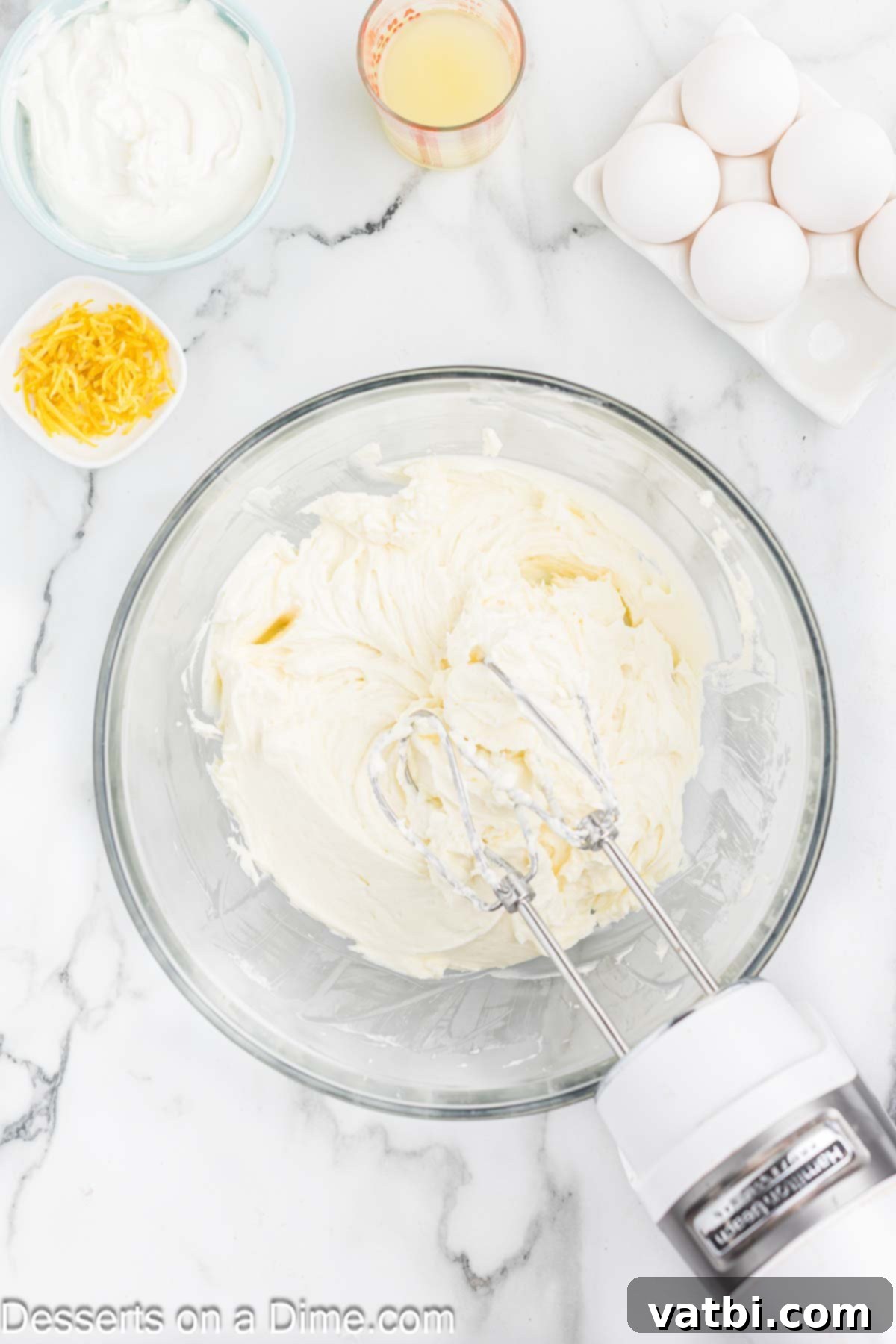 Luscious Lemon Blueberry Cheesecake 5 Cream cheese mixture in a large mixing bowl, showing a smooth and well-combined batter.