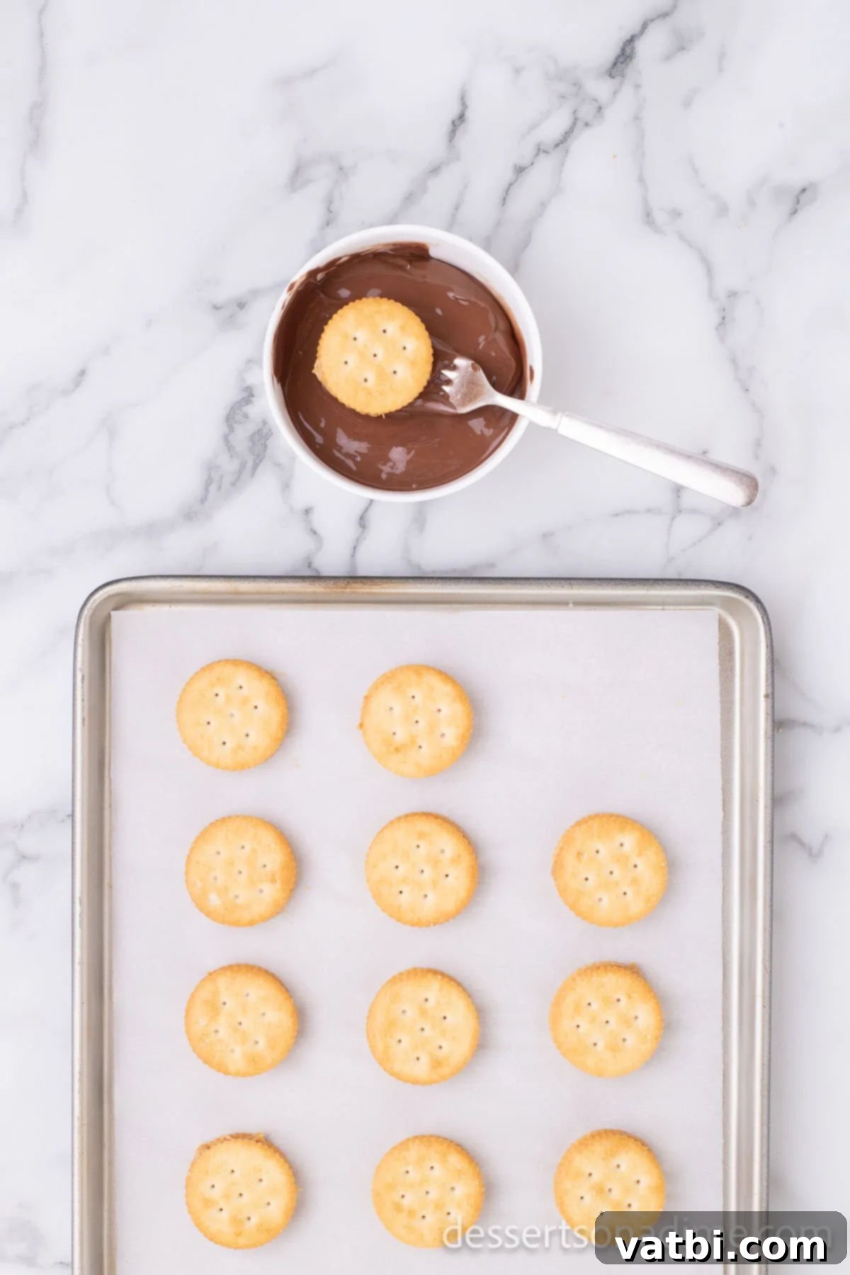 Sweet and Salty Chocolate Ritz Bites 6 A peanut butter and Ritz cracker sandwich being carefully dipped into the bowl of rich, melted chocolate, ensuring full coverage.