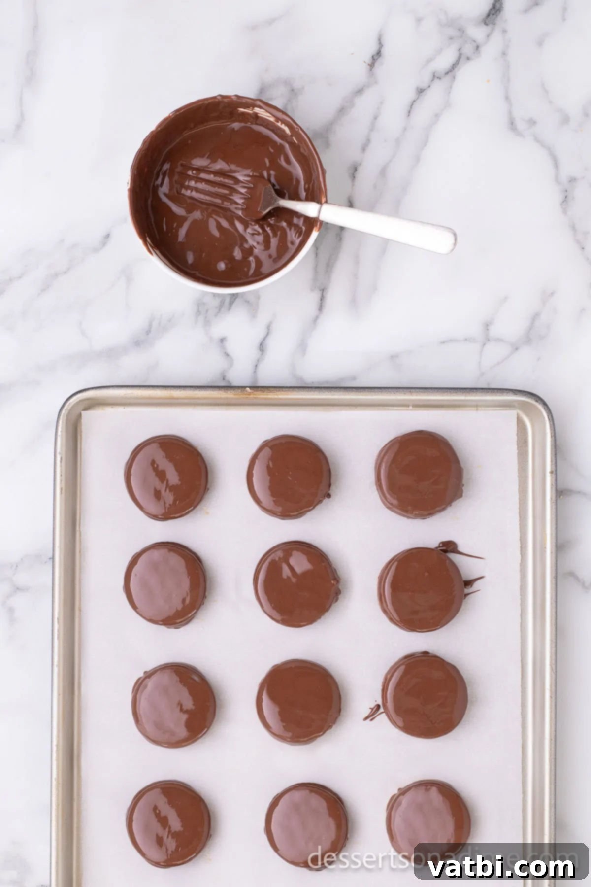 Sweet and Salty Chocolate Ritz Bites 8 All the chocolate-covered peanut butter and Ritz cracker sandwiches arranged neatly on a parchment paper-lined baking sheet, fully cooled and set, ready to be enjoyed.