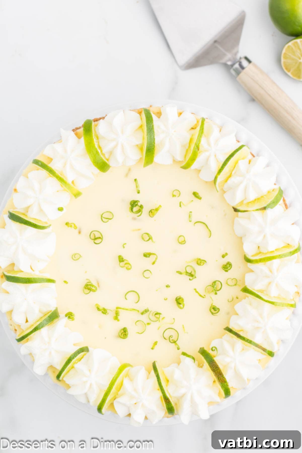 Key Lime Cheesecake 10 Key Lime Cheesecake topped with a generous swirl of whipped cream and garnished with fresh lime slices.