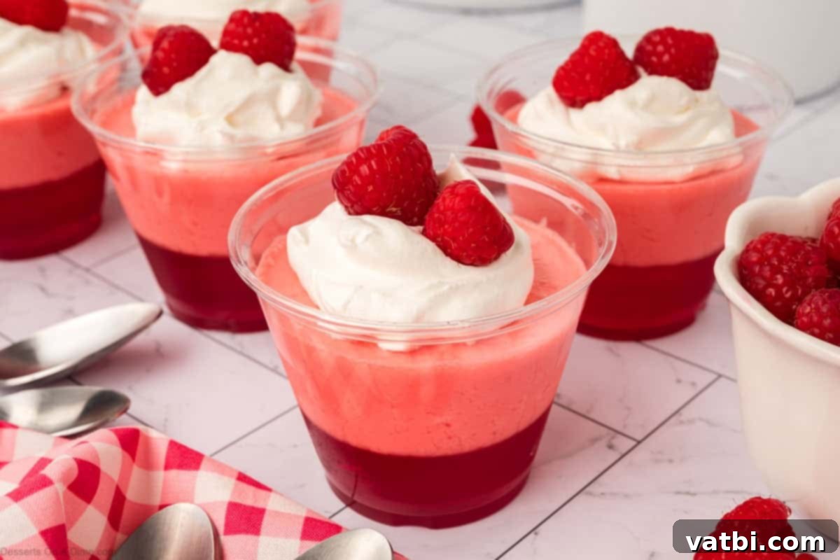 Layered Jello Parfait 2 Jello Parfait in cups topped with fresh raspberries and whipped cream.