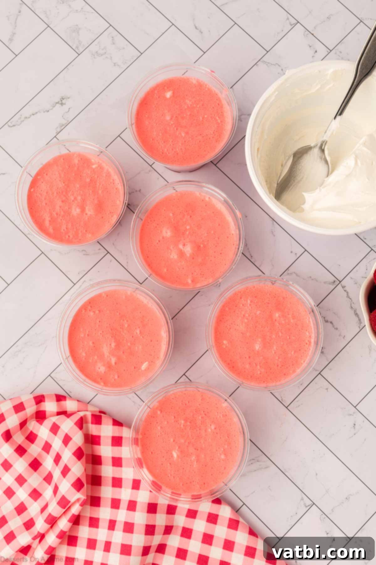 Layered Jello Parfait 10 Cream cheese Jell-o mixture being spooned over the set Jello layer in cups.