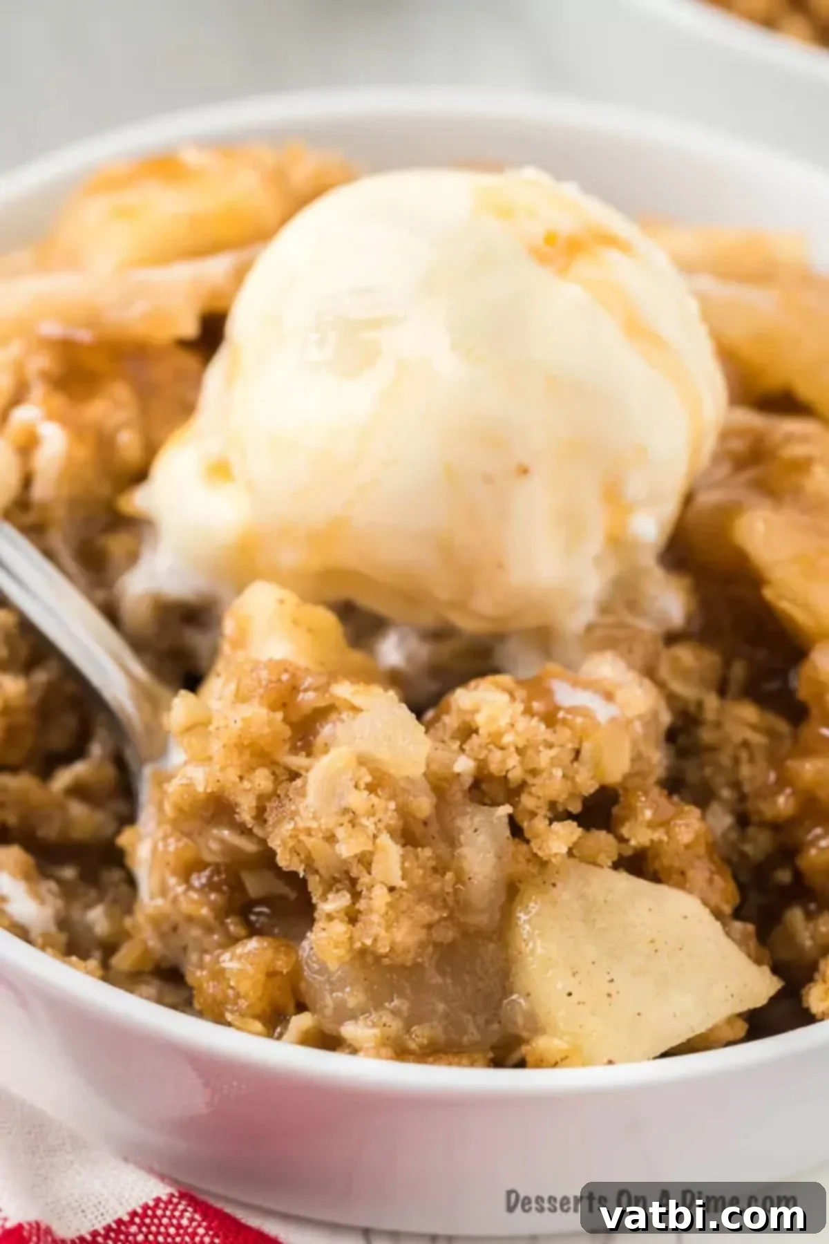Classic Apple Crisp 12 Apple crisp in a bowl topped with ice cream.