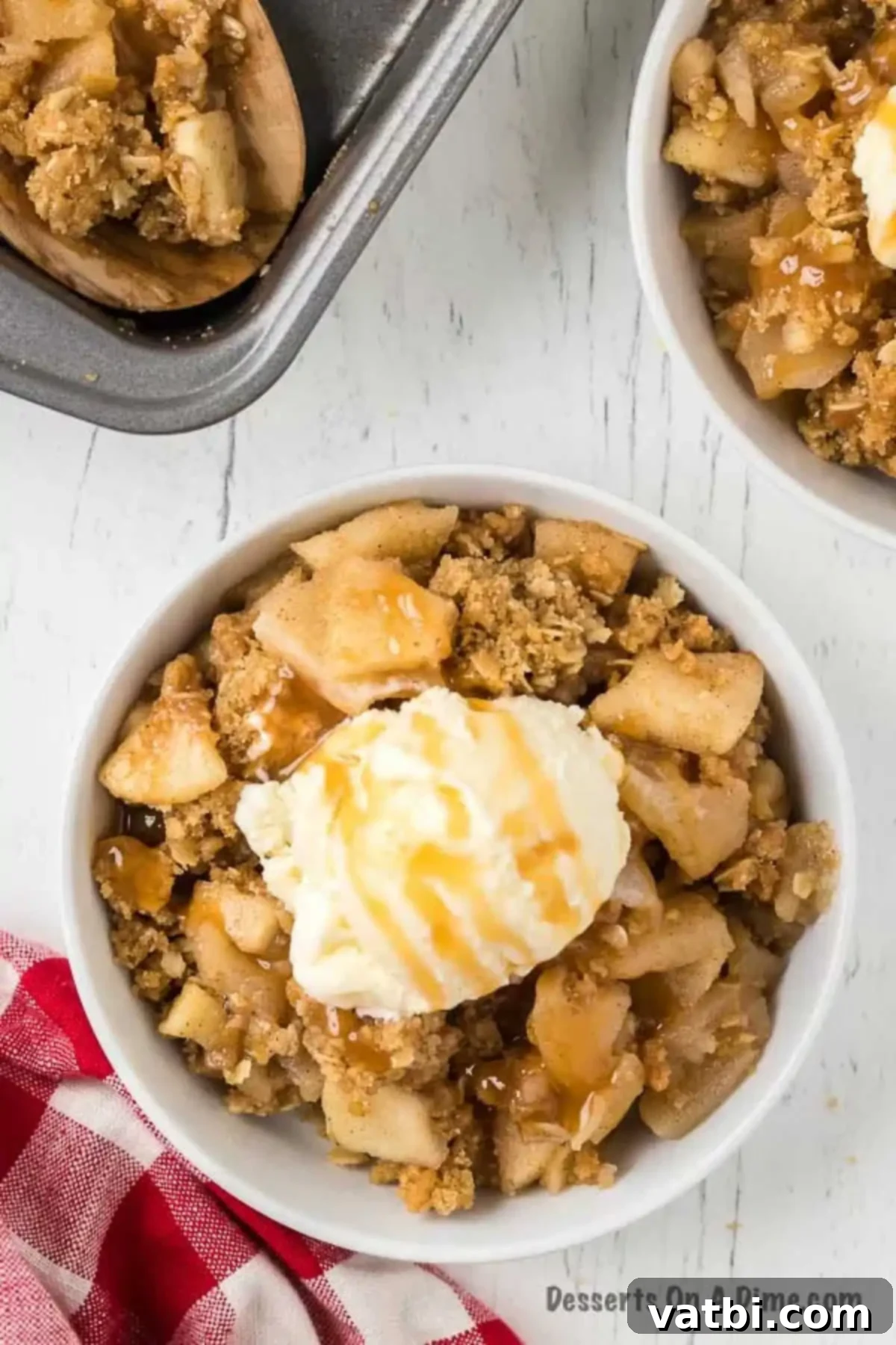 Classic Apple Crisp 3 Apple crisp in a bowl with ice cream and caramel sauce.