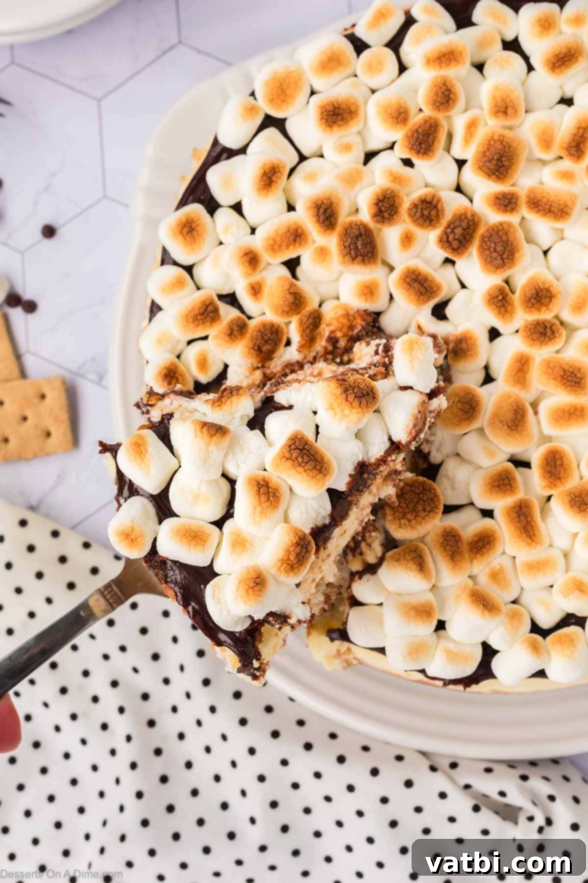 Smores Cheesecake 15 S'mores cheesecake being sliced, revealing its delicious layers.