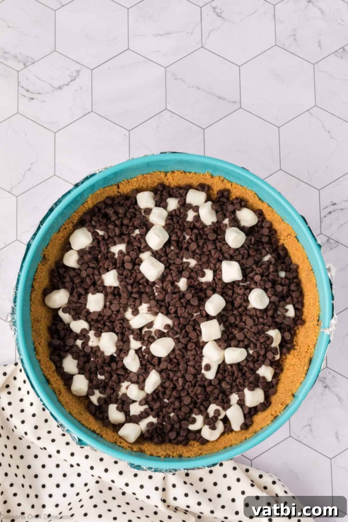 Smores Cheesecake 7 Mini chocolate chips and marshmallows sprinkled over the baked crust.