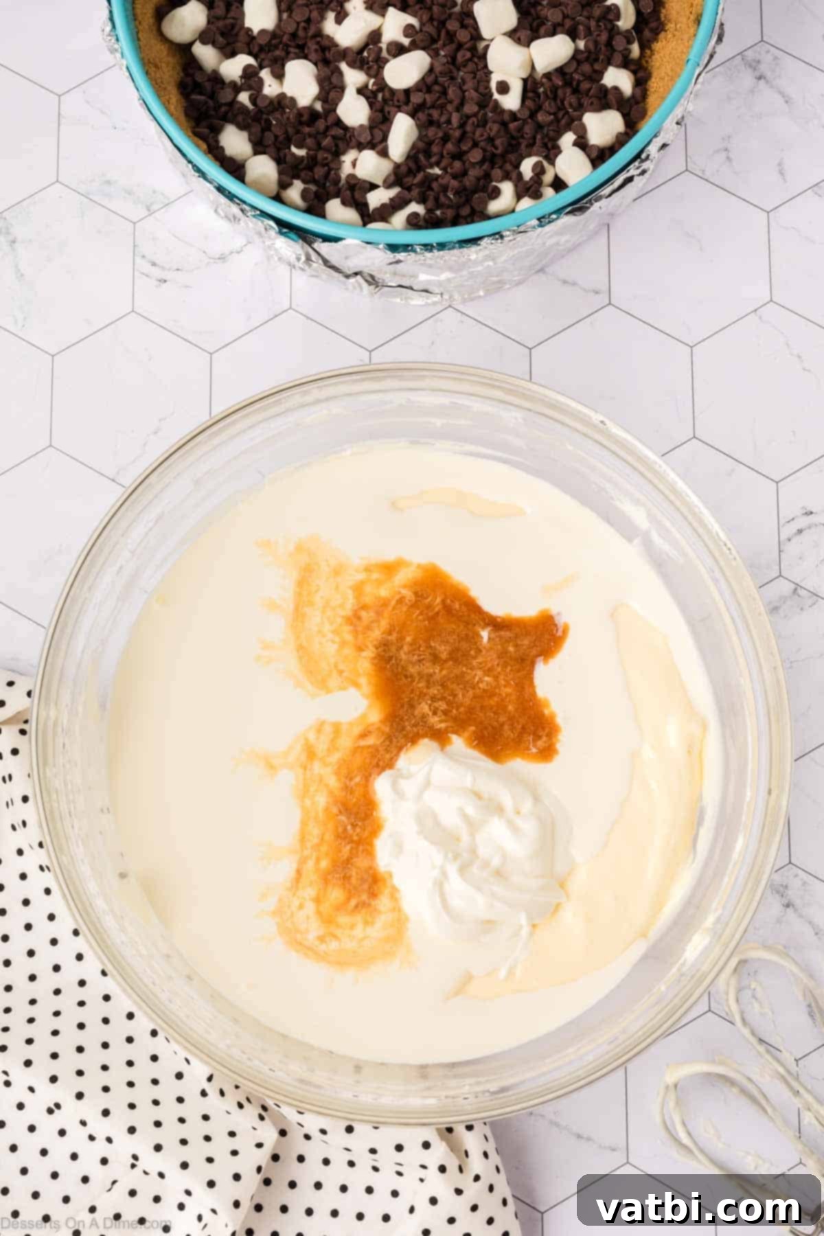 Smores Cheesecake 9 Vanilla extract, sour cream, and eggs being added to the cream cheese mixture.
