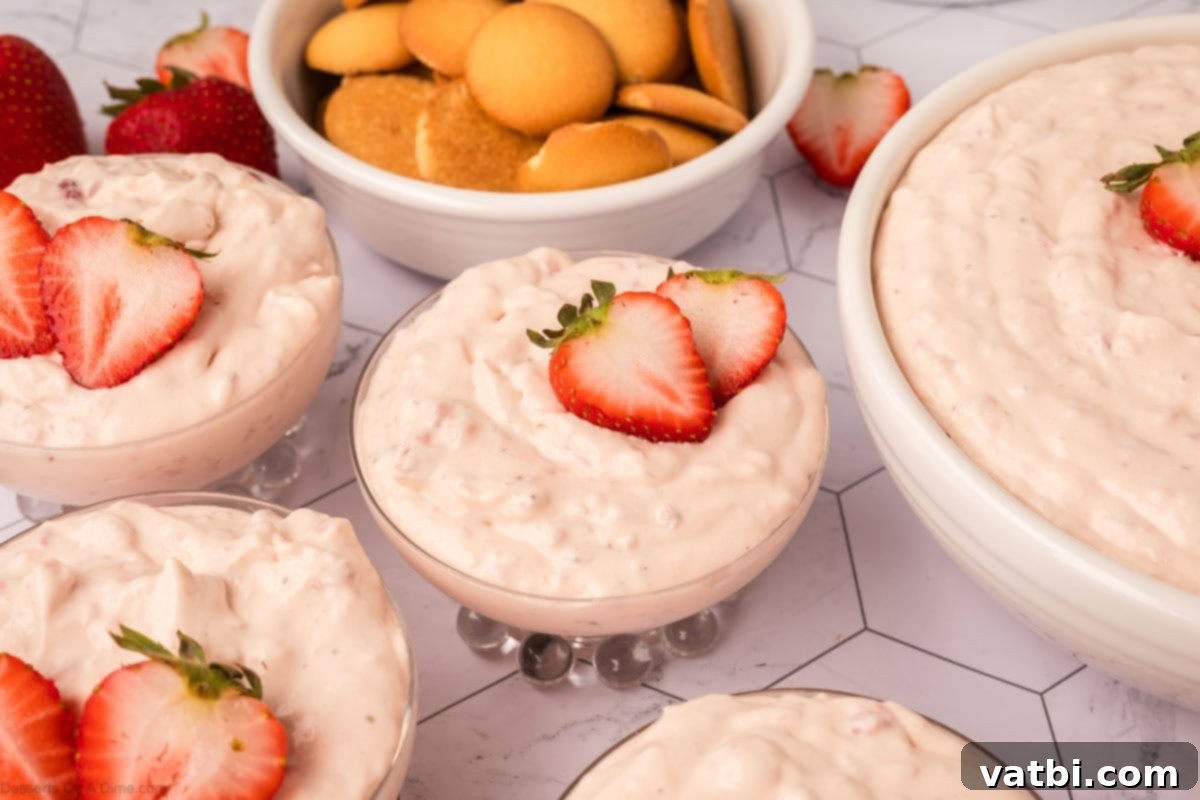Bowls of creamy strawberry cheesecake fluff, garnished with fresh berries.