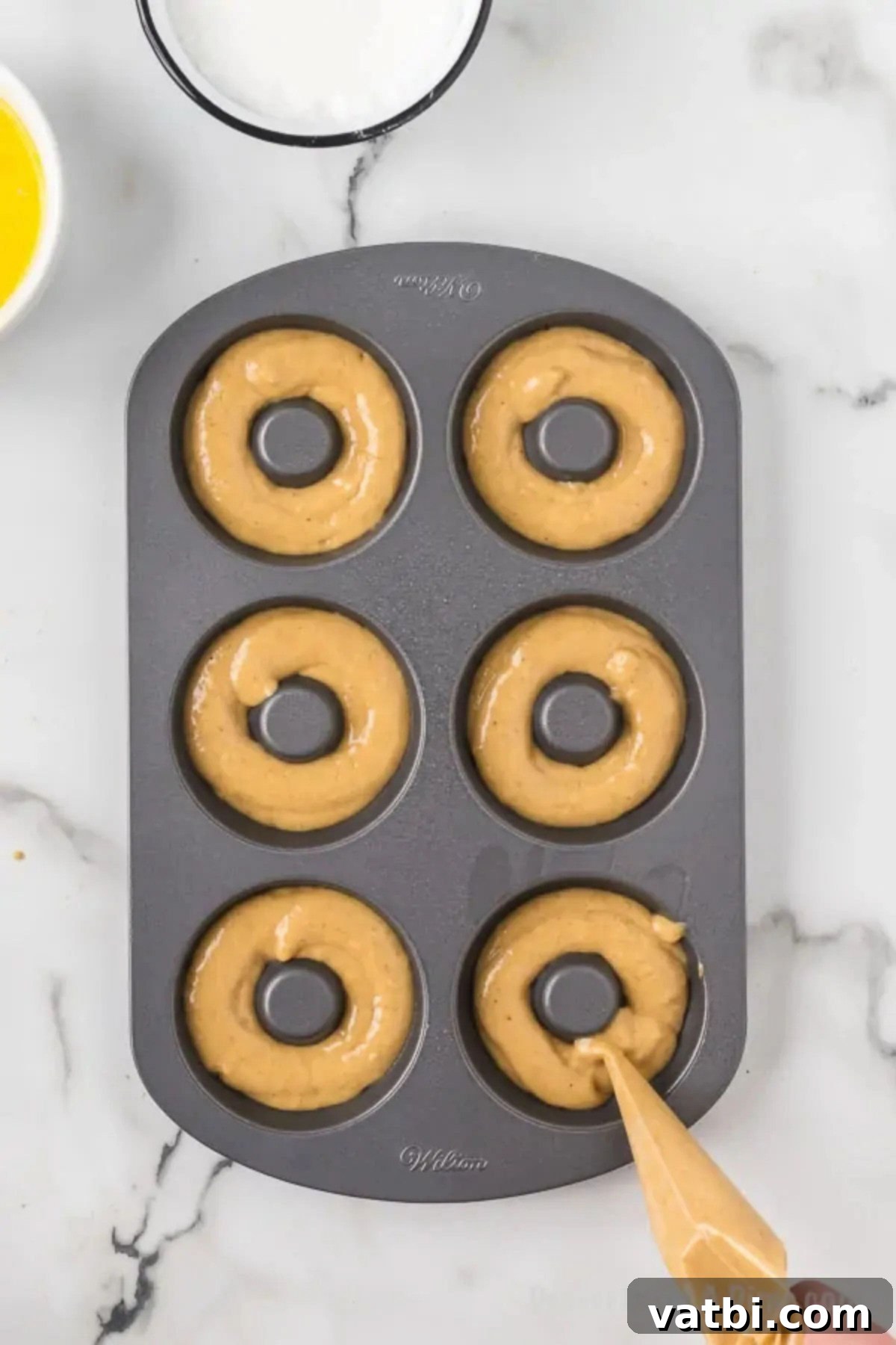 Spiced Apple Cider Baked Doughnuts 7 Batter piped into doughnut pan.