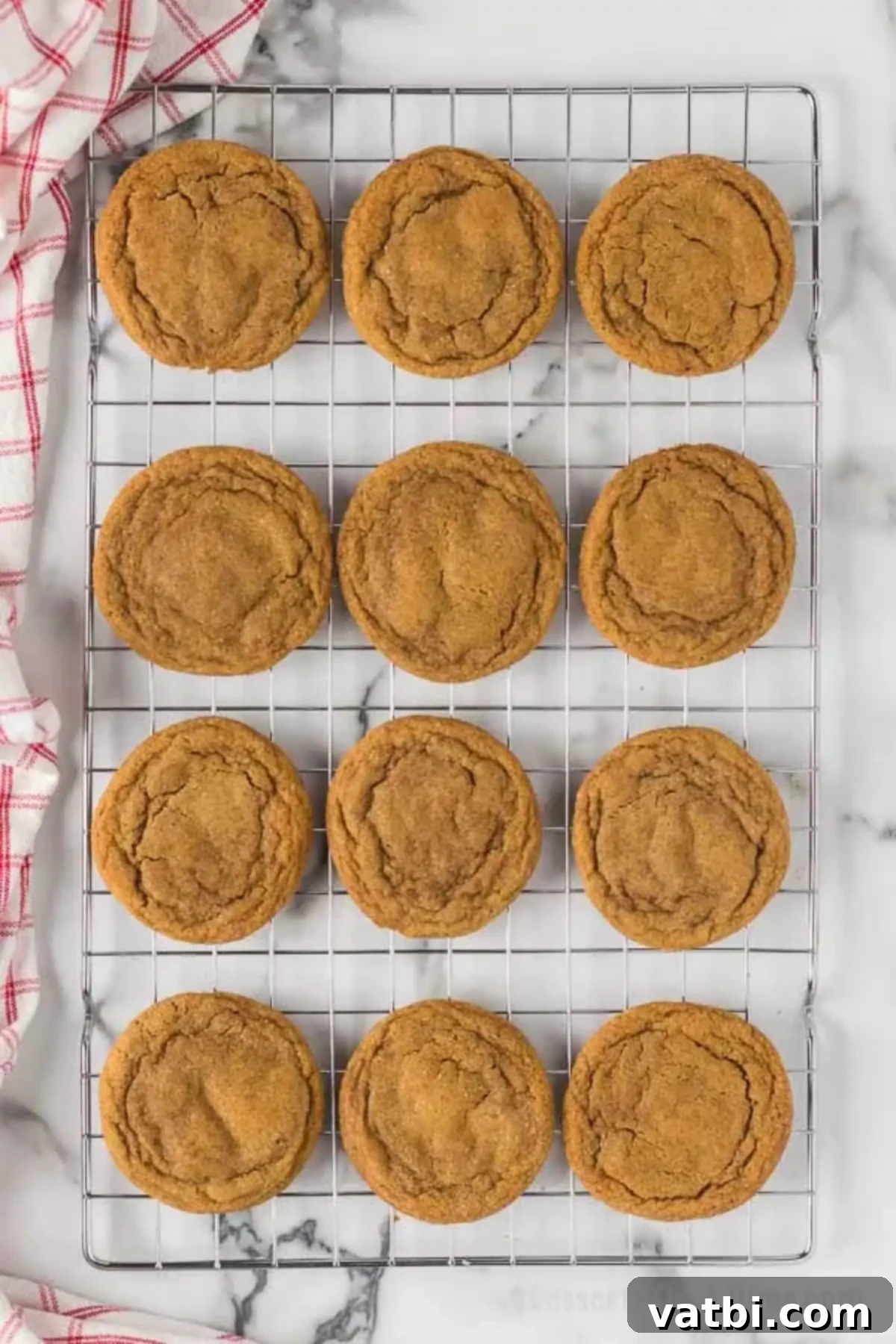 Chewy Ginger Molasses Cookies 12 Freshly baked ginger molasses cookies cooling on a metal wire rack.