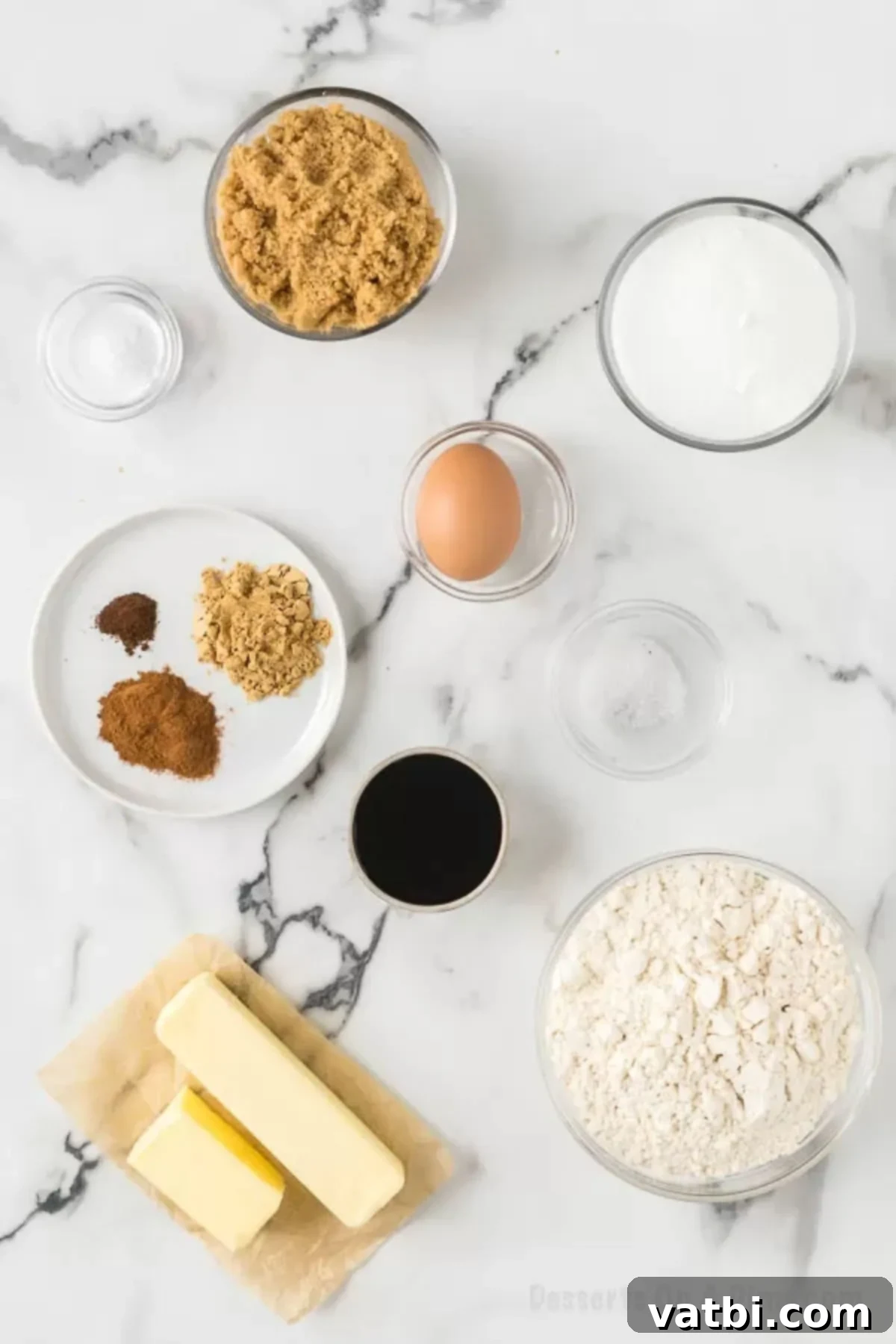 Chewy Ginger Molasses Cookies 3 Ingredients for Ginger Molasses Cookies including flour, ground ginger, baking soda, cinnamon, cloves, butter, brown sugar, molasses, and eggs, arranged neatly on a surface.