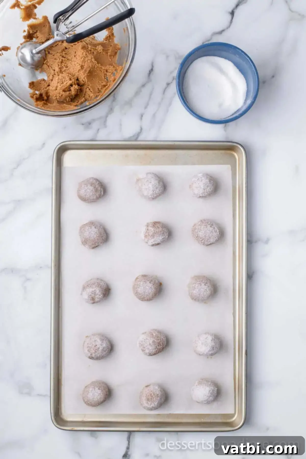 Chewy Ginger Molasses Cookies 10 Ginger molasses cookie dough balls rolled in granulated sugar and placed on a baking sheet, spaced apart.