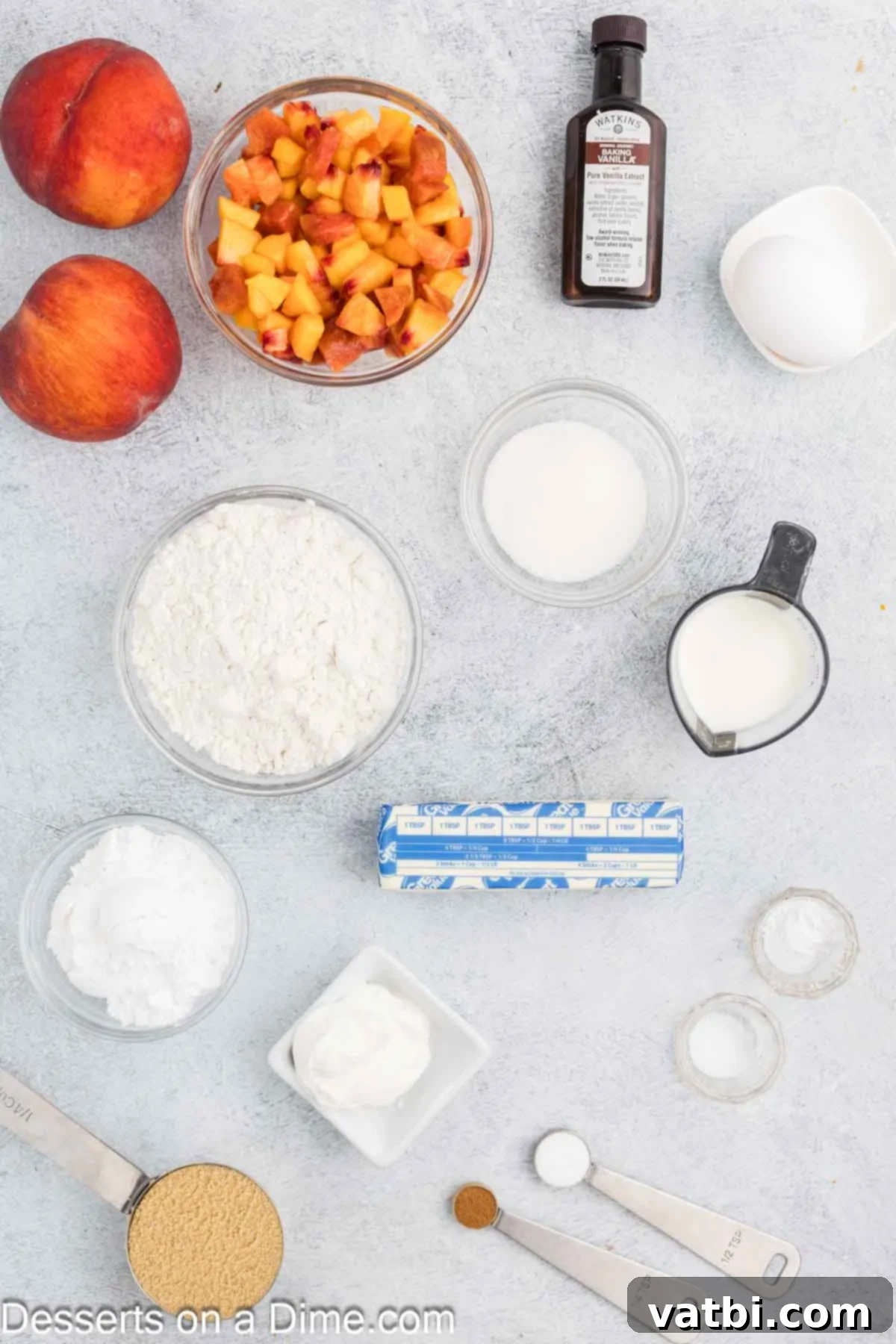 Ingredients for peach bread - flour, baking powder, baking soda, cinnamon, salt, butter, brown sugar, white sugar, egg, vanilla, sour cream, peaches arranged beautifully.