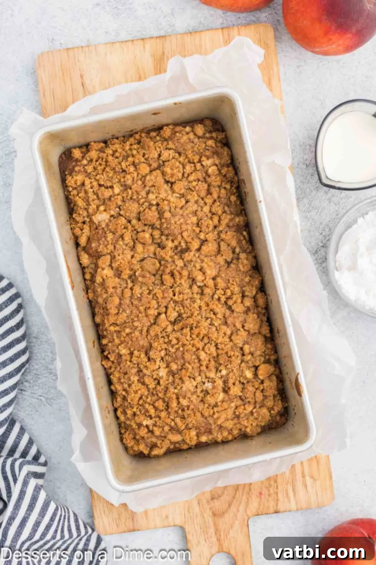 Baked peach bread cooling in the loaf pan on a wire rack.