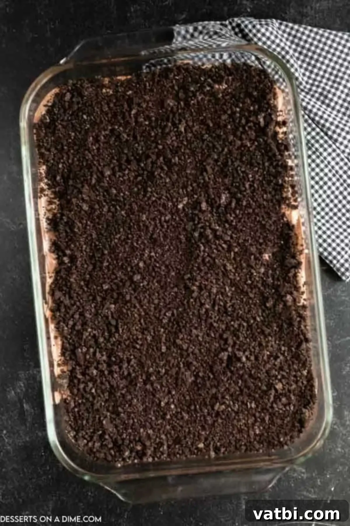 Spooky Halloween Dirt Cake 10 The final layer of crushed Oreo cookies generously sprinkled over the set pudding, creating the signature 'dirt' appearance for the Halloween cake.