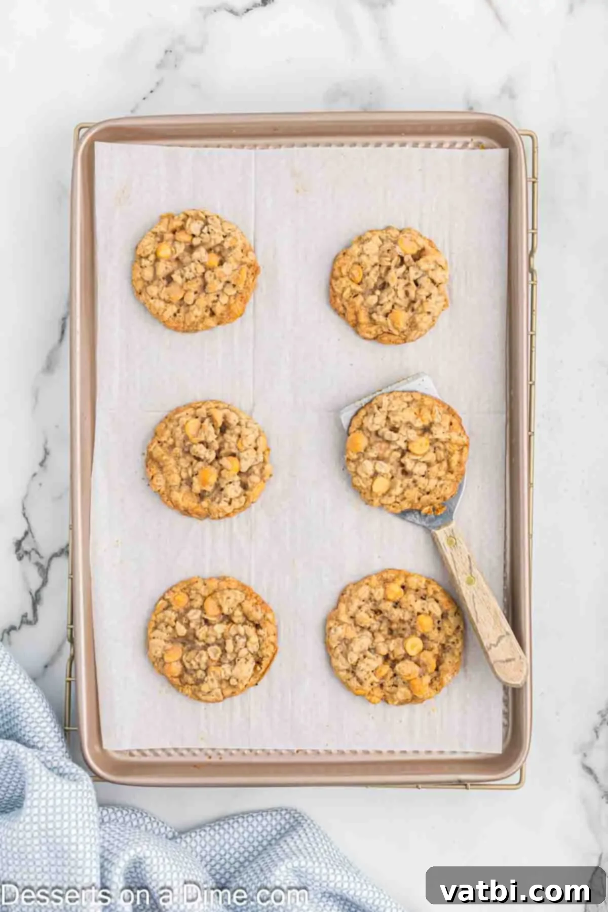 Oatmeal Butterscotch Cookies 8 Freshly baked Oatmeal Butterscotch cookies cooling on a baking sheet before transfer to a wire rack.