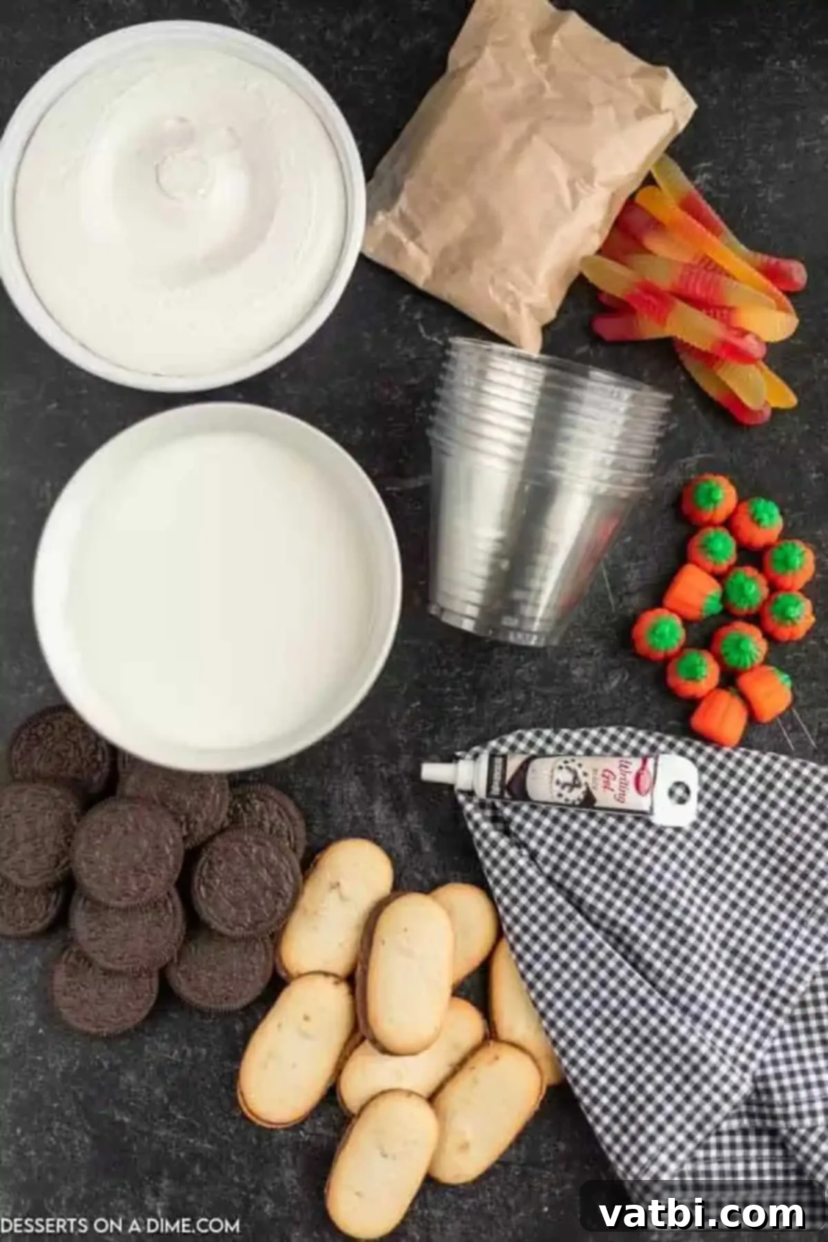 Spooky Halloween Dirt Cups 3 A selection of ingredients for Halloween dirt cups, including Cool Whip, candy worms, candy pumpkins, Oreo cookies, milk, and chocolate pudding mix.