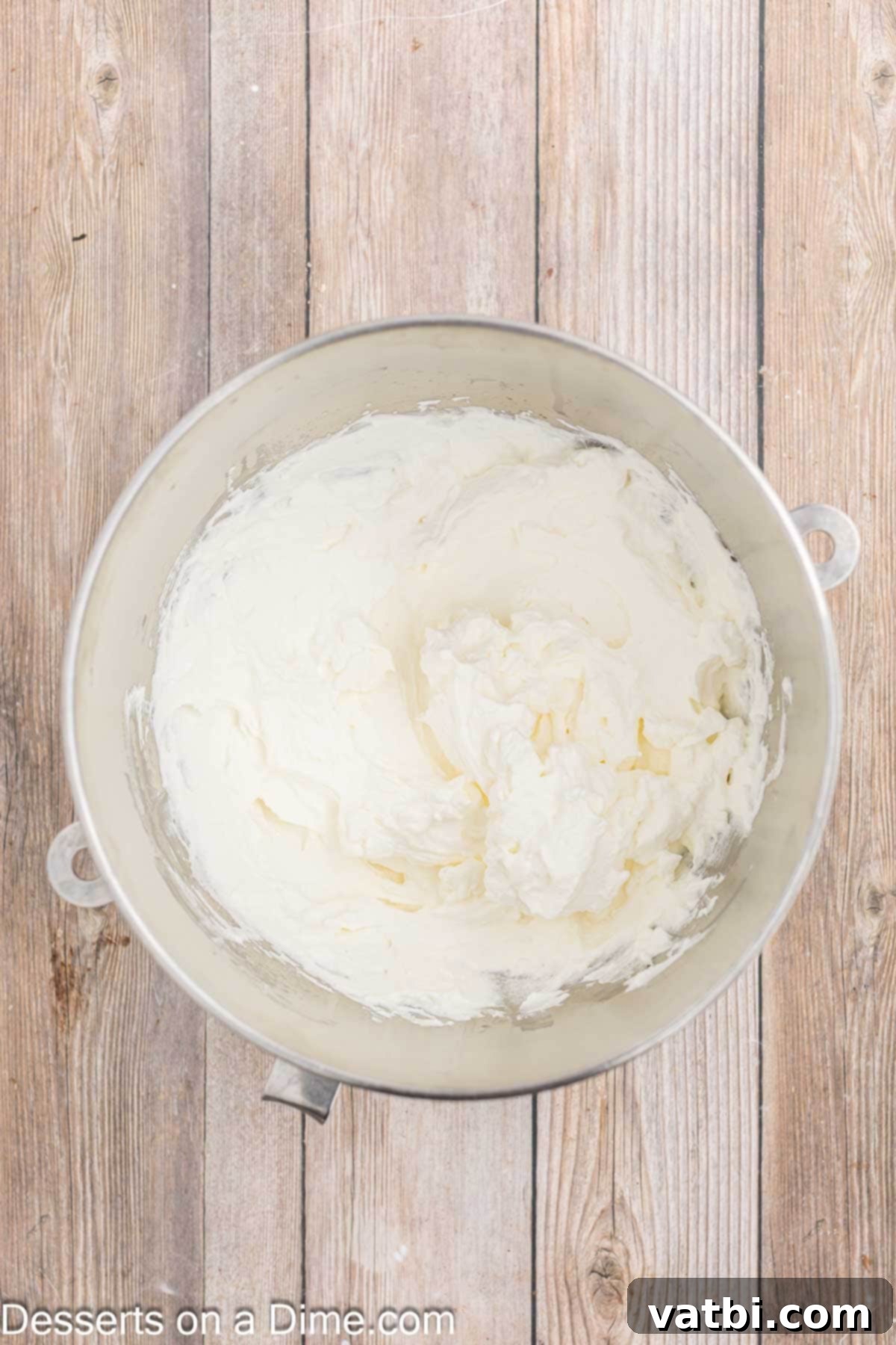 Decadent Banana Cheesecake 11 Freshly made whipped topping in a mixing bowl.