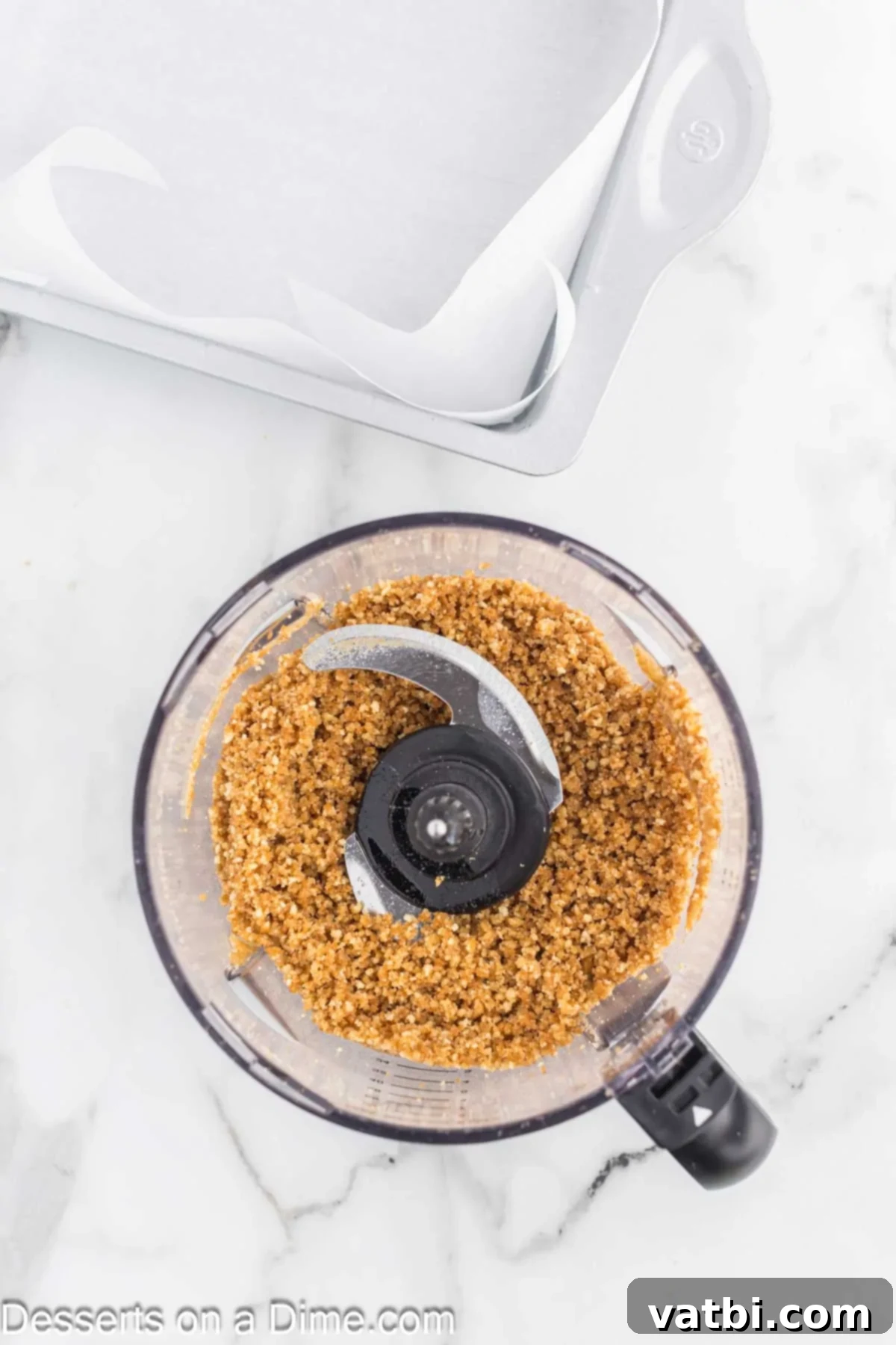 Decadent Banana Cheesecake 4 Nilla wafers crumbs being processed in a food processor.