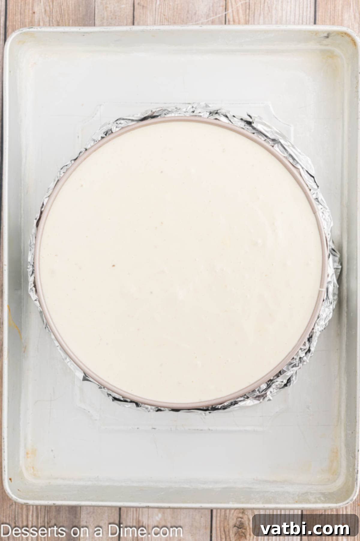 Decadent Banana Cheesecake 9 Cheesecake in a springform pan placed in a water bath inside a roasting pan.
