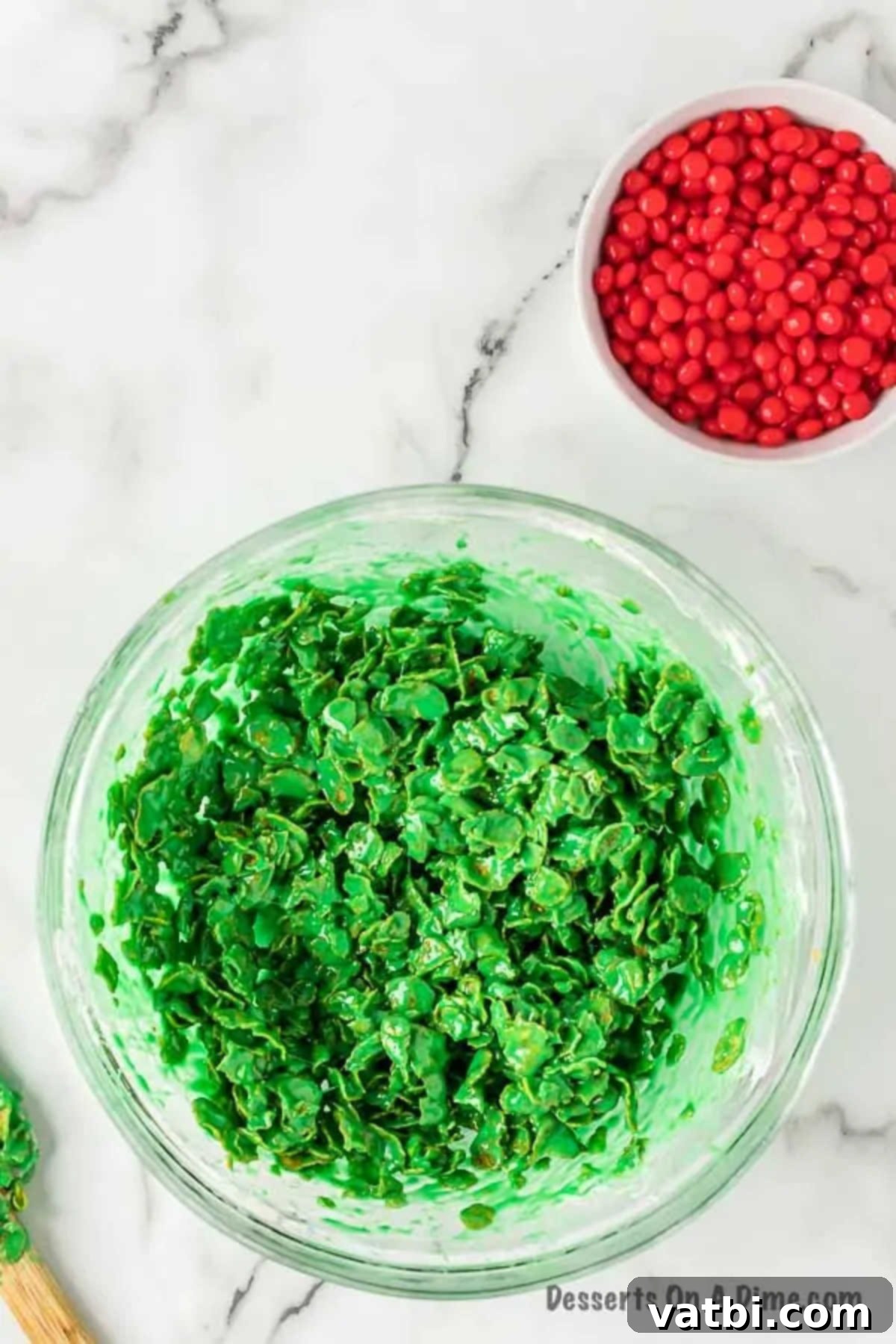 Sweet Christmas Wreath Delights 6 Cornflake cereal coated in green marshmallow mixture in a large mixing bowl.
