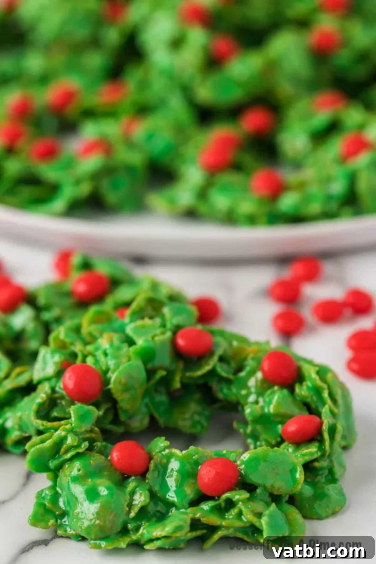 Sweet Christmas Wreath Delights 10 Platter of vibrant green Christmas wreath cookies, two in the foreground, ready for holiday serving.