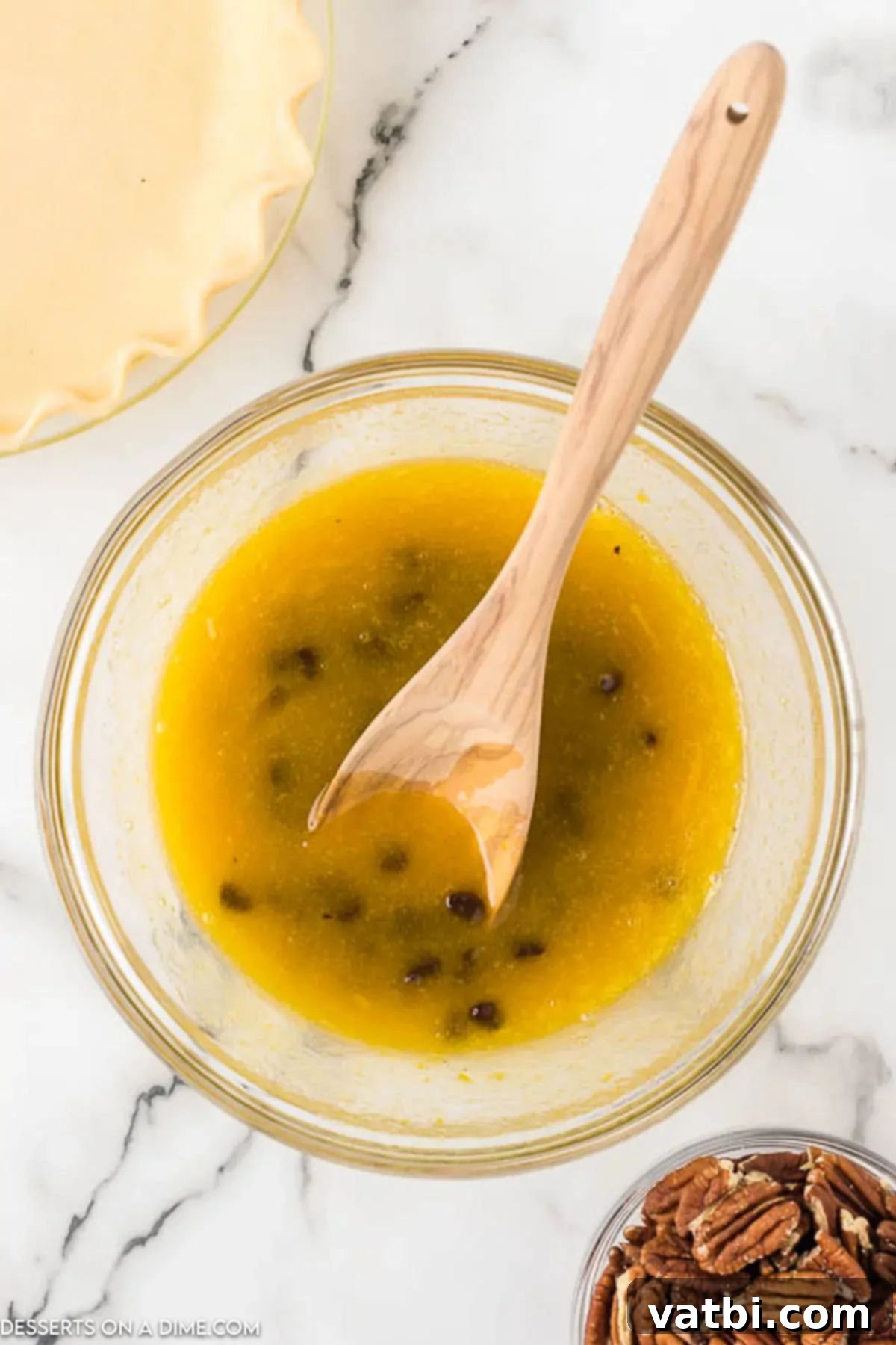 Mixing bowl with eggs, sugar, corn syrup, chocolate, butter, and vanilla extract for pecan pie filling. 